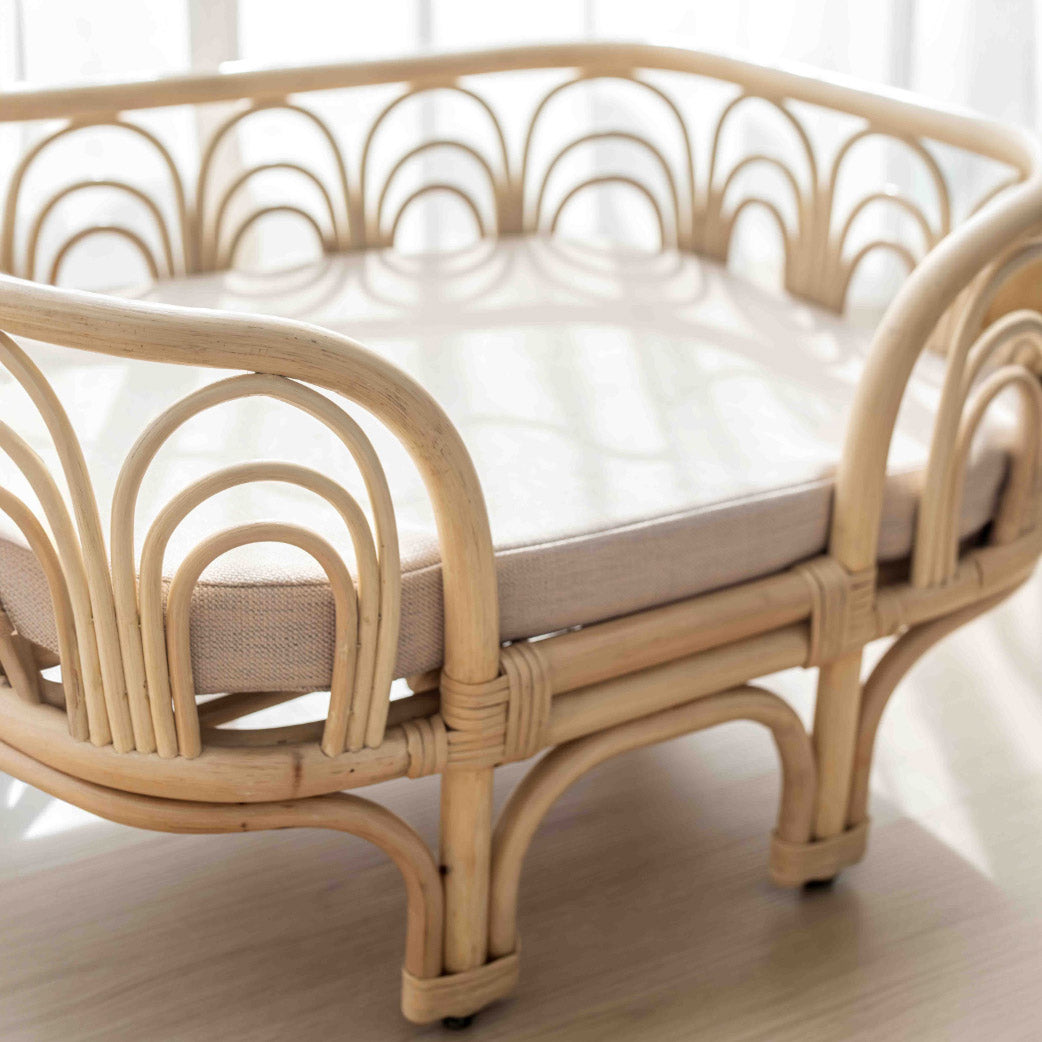 Amber Rattan Pet Bed by MOMIJI close up side view in a bed room.