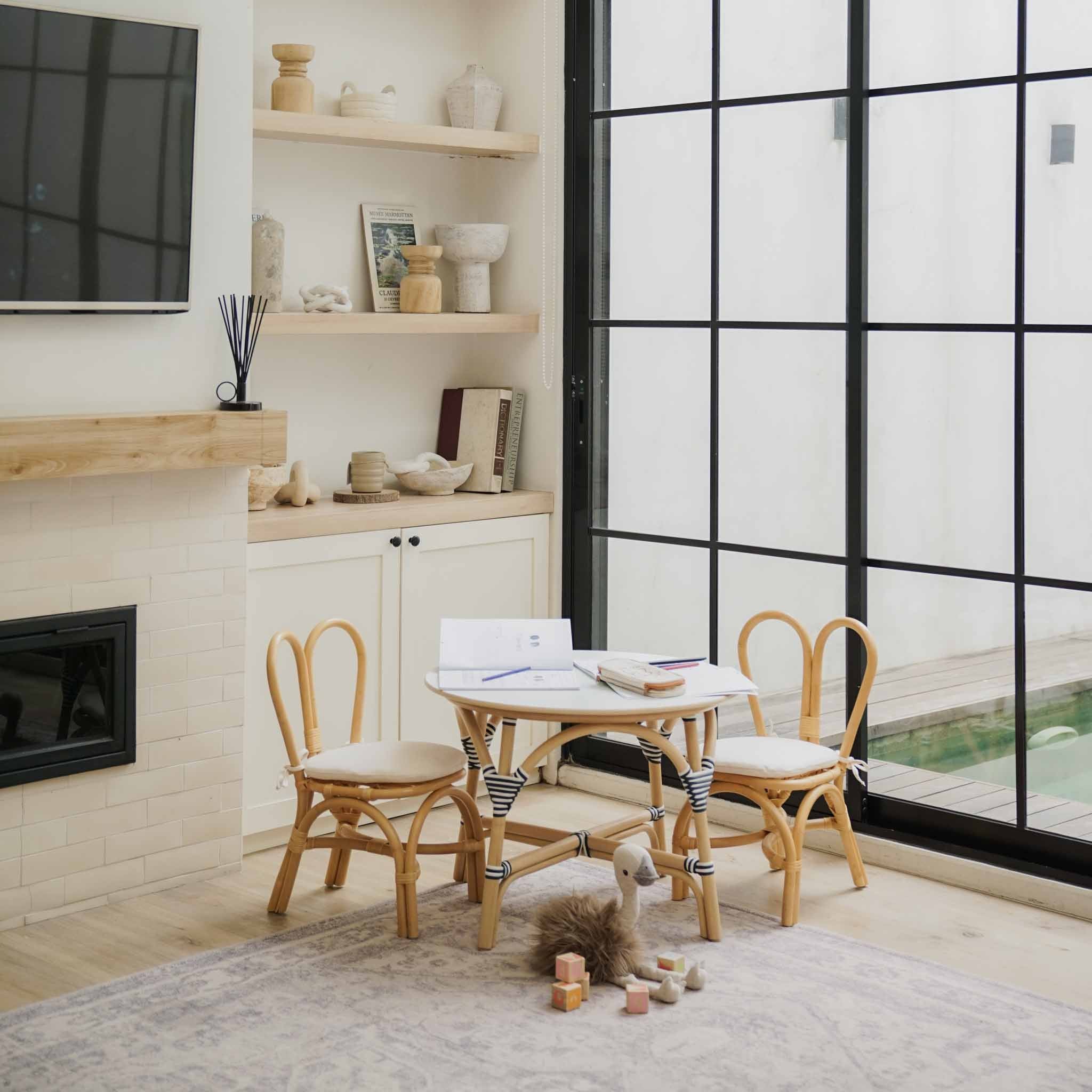 Close up detail shot of a handcrafted rattan wicker Aulia Kids Table (Medium) & Set of 2 Bunny Kids Chairs (Natural) by MOMIJI in a Montessori playroom setup.