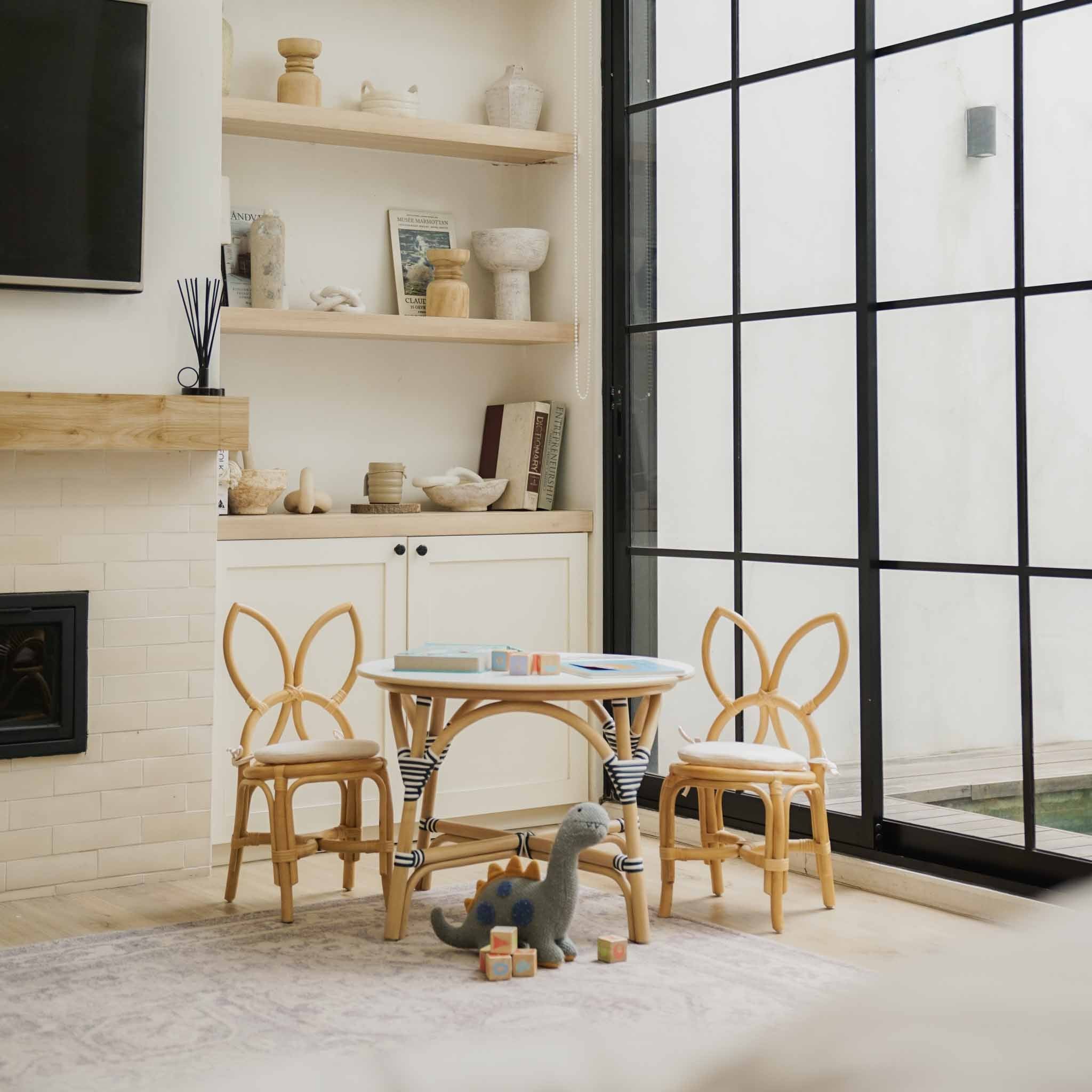 Close up detail shot of a handcrafted rattan wicker Aulia Kids Table (Medium) & Set of 2 Butterfly Kids Chairs (Natural) by MOMIJI in a Montessori playroom setup.