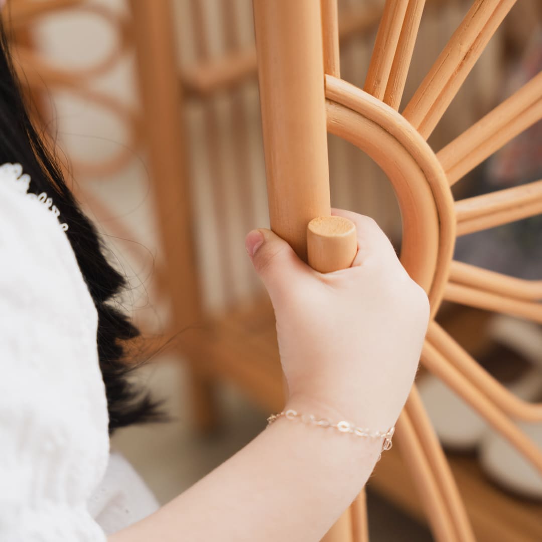 Close-up of a child holding the door handle of the Blossom Doll Closet by MOMIJI.