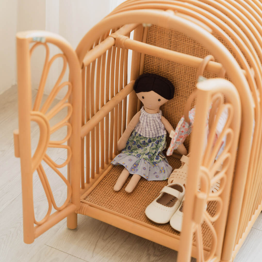 Blossom Doll Closet by MOMIJI with doors open, showing dolls, clothes, and shoes inside an indoor setting.