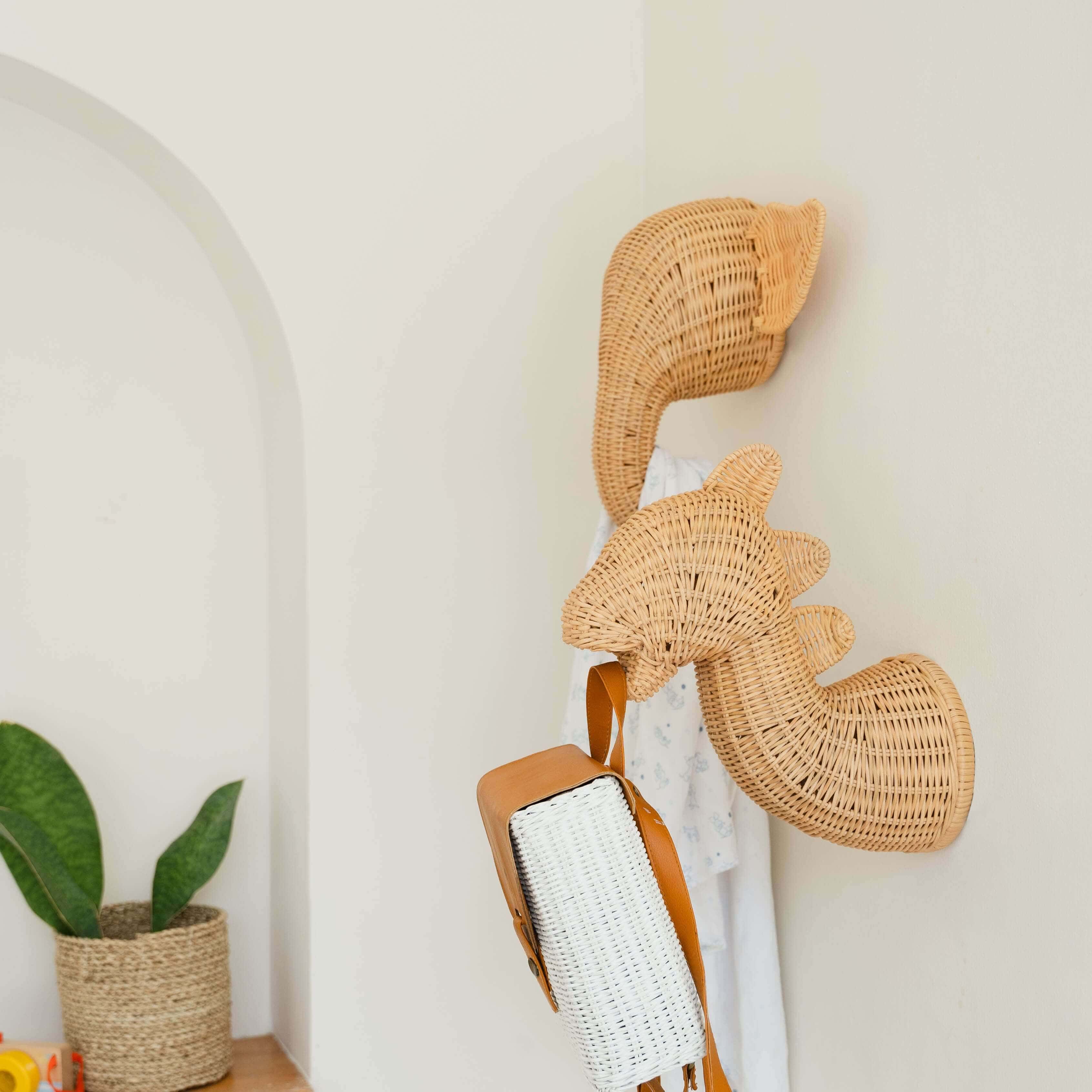 Side view of the elephant and dinosaur wall decor by MOMIJI used as wall hooks in a decorative room.