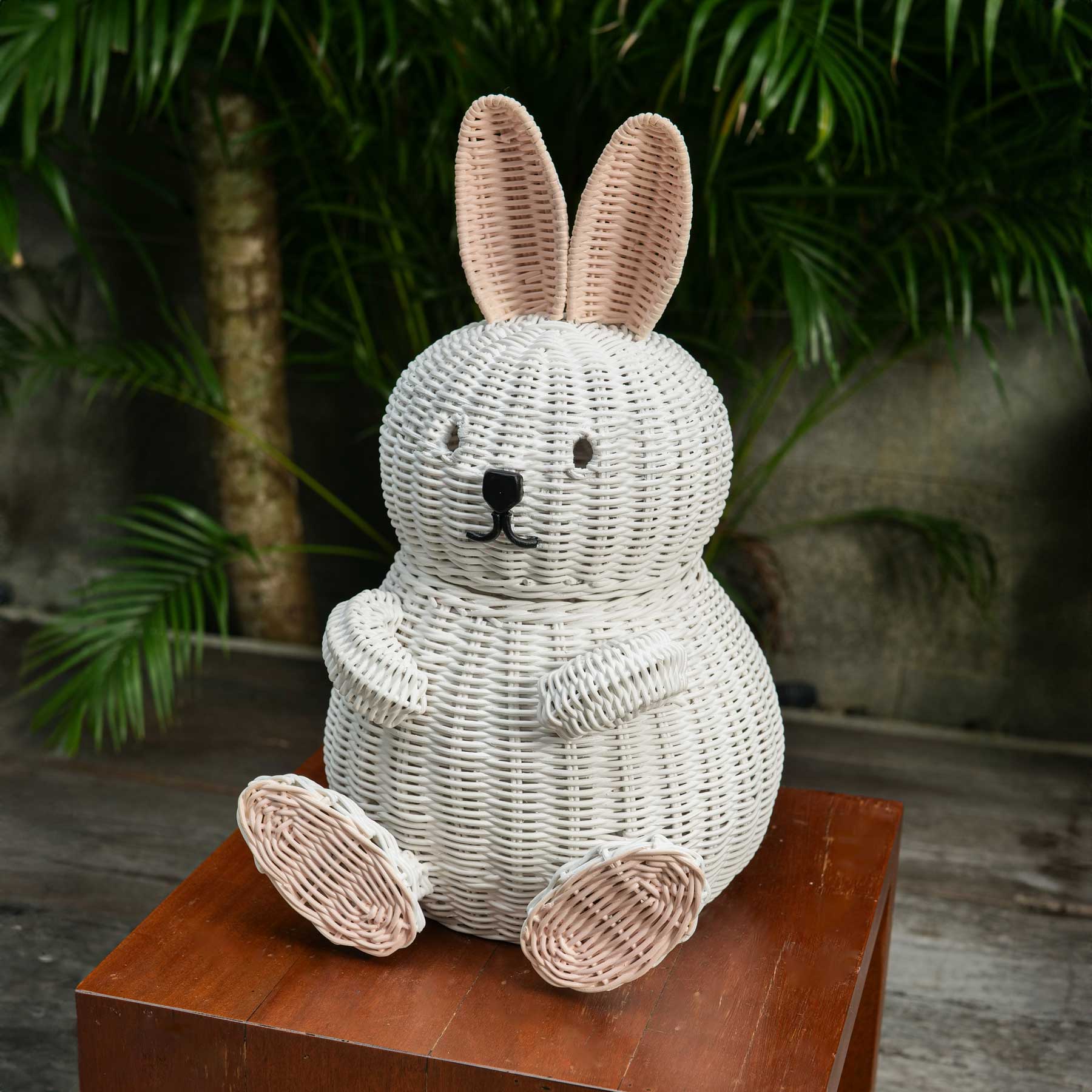 Bunny Rattan Storage Basket by MOMIJI on a wooden table with a natural background.