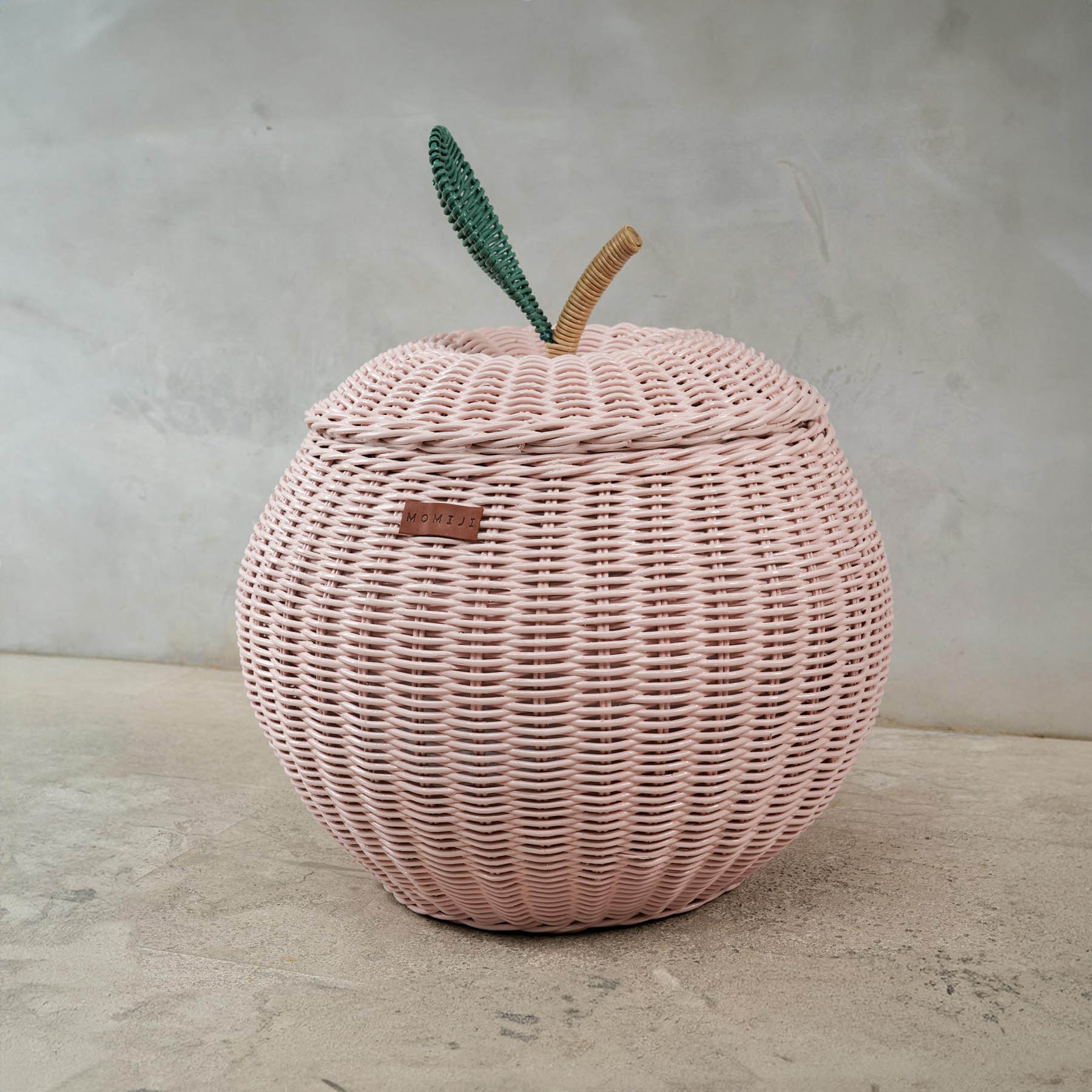 Side view of a pink apple rattan storage basket by MOMIJI in medium size.