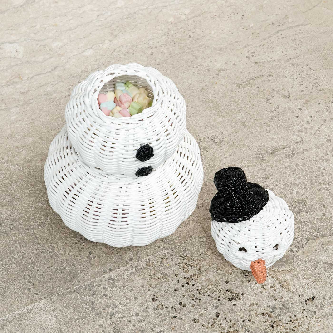 Snowman 3 Tier Rattan Storage Basket with marsh mallows inside the basket and snowman head lid on the floor.