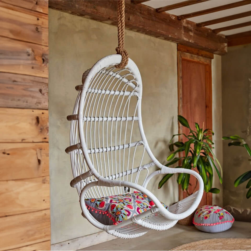 Nest Hanging Chair by MOMIJI with a colorful cushion, styled outdoors.