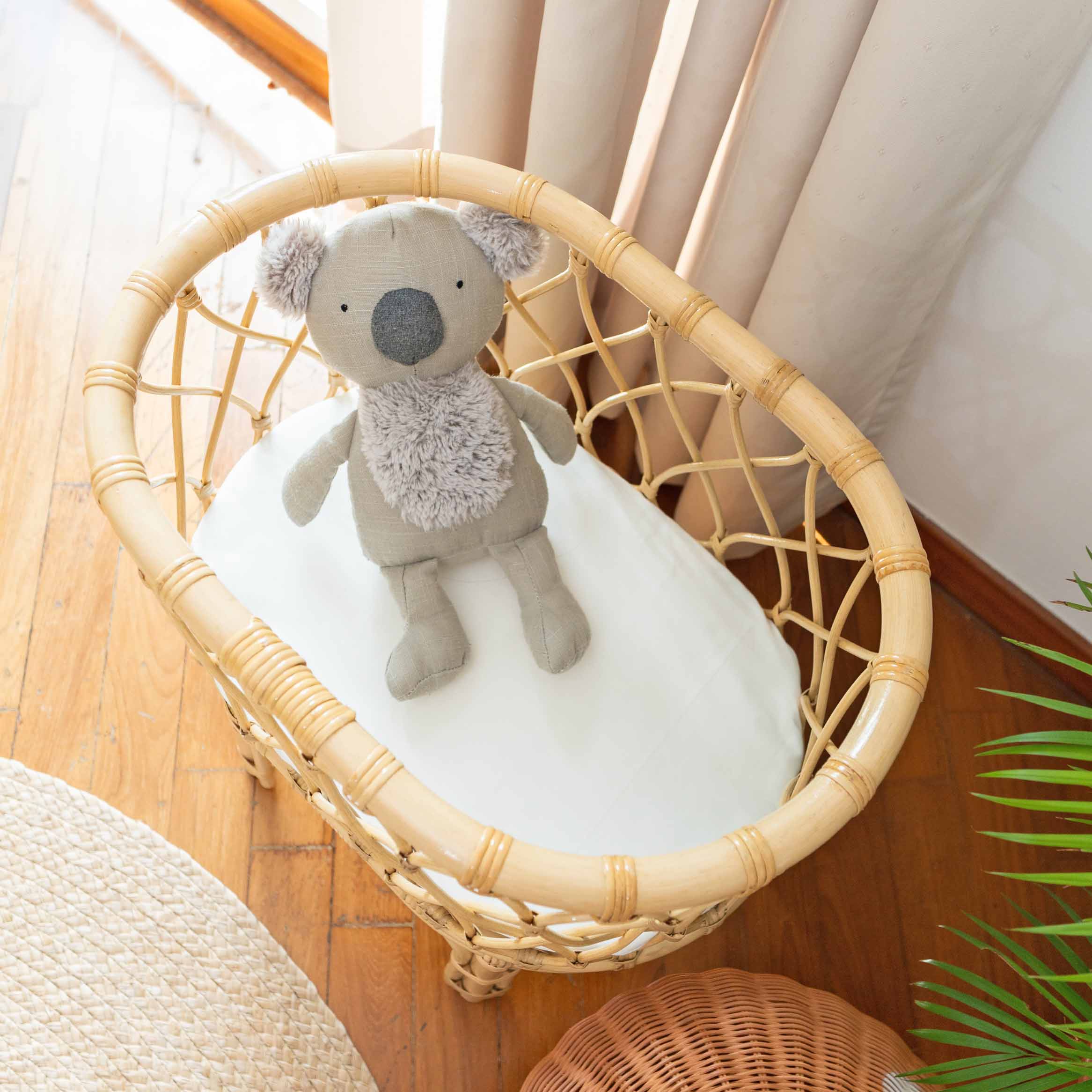 Top view of the Olivia Doll Bassinet by MOMIJI with a koala doll standing inside.