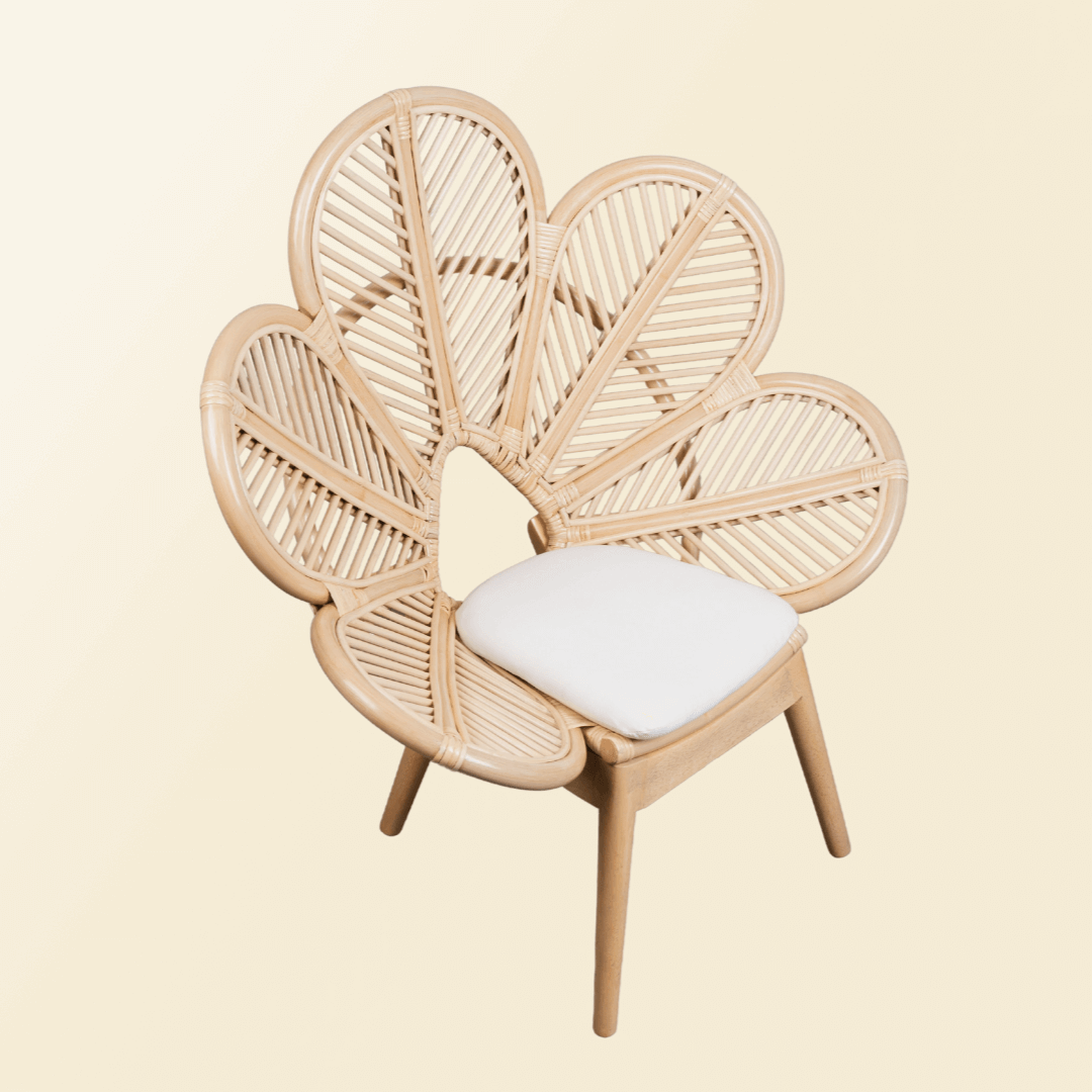 Tilted view of handcrafted rattan wicker Petal Kids Chair by MOMIJI with white cushion, showing its balanced structure and floral design.