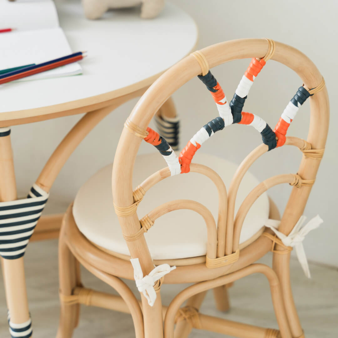 Back view of handcrafted rattan wicker Quentin Kids Chair by MOMIJI, showing the backrest with navy, white, and orange color accents.