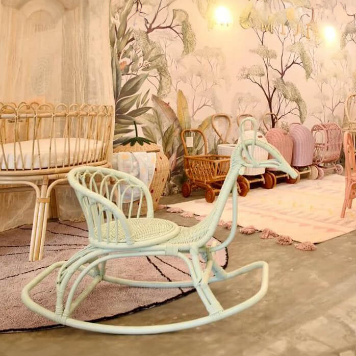 Mint Rocking Peacock by MOMIJI placed in a room with floral wallpaper and surrounding furniture.