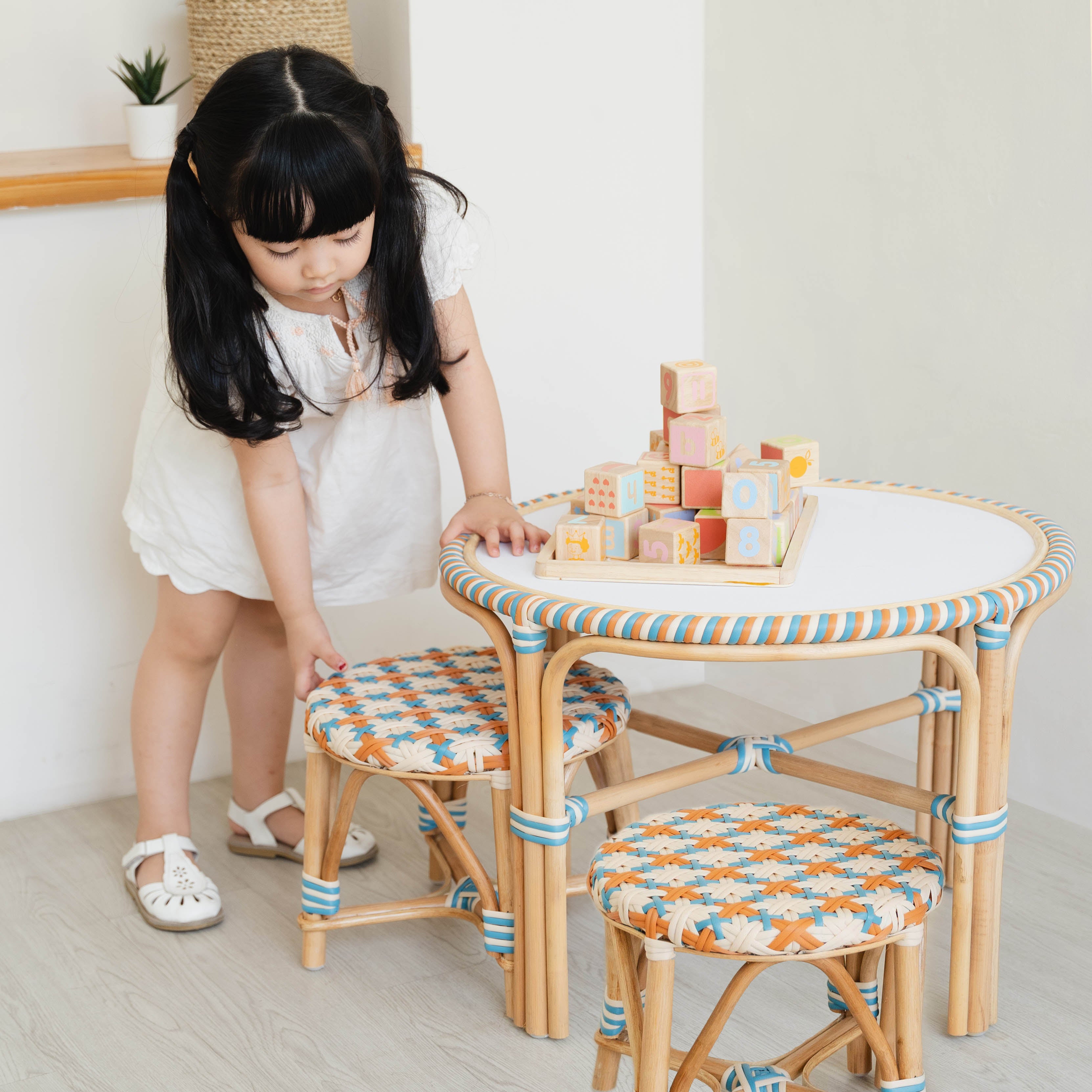 Rattan Table Set | Xander Kids Table & Stools | Wooden Block Toys on the Table | Child Pulling Rattan Stool | MOMIJI
