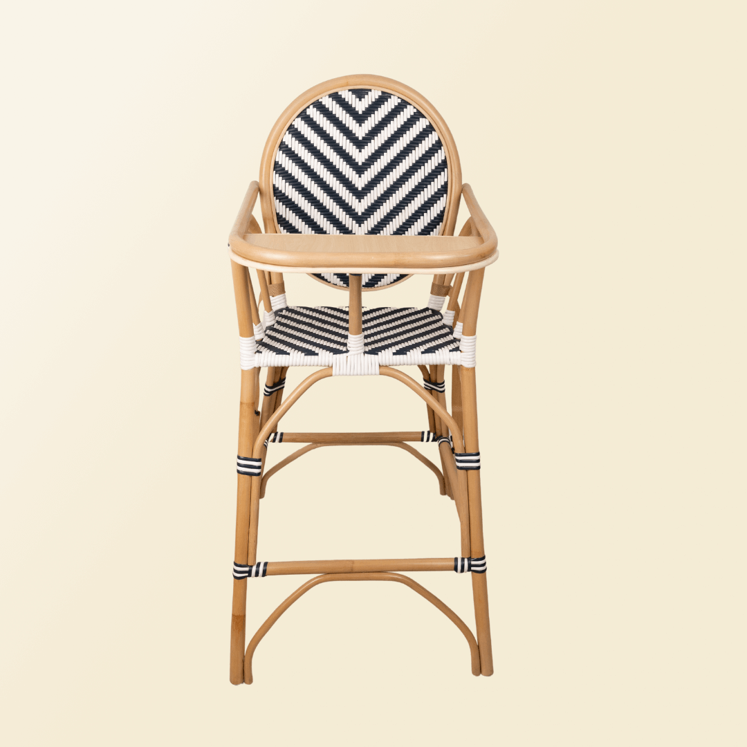 Front view of the Handcrafted rattan wicker Tumbuh Kids High Chair by MOMIJI with the tray attached, showing a sturdy, child-safe structure with black and white woven details on the backrest, seat, and reinforced wrapped joint.
