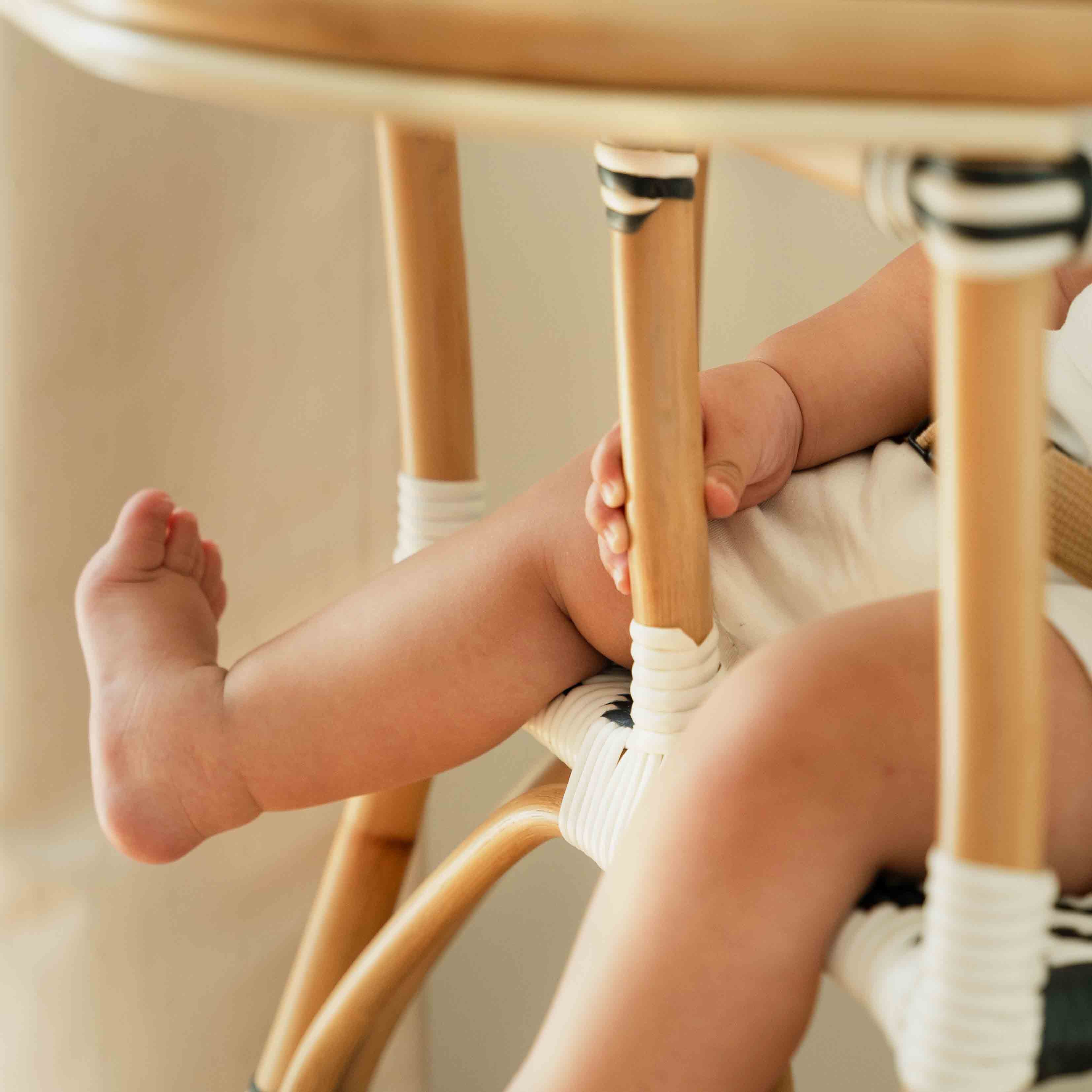 Close-up of the perforated footrest detail of the Handcrafted rattan wicker Tumbuh Kids High Chair by MOMIJI.