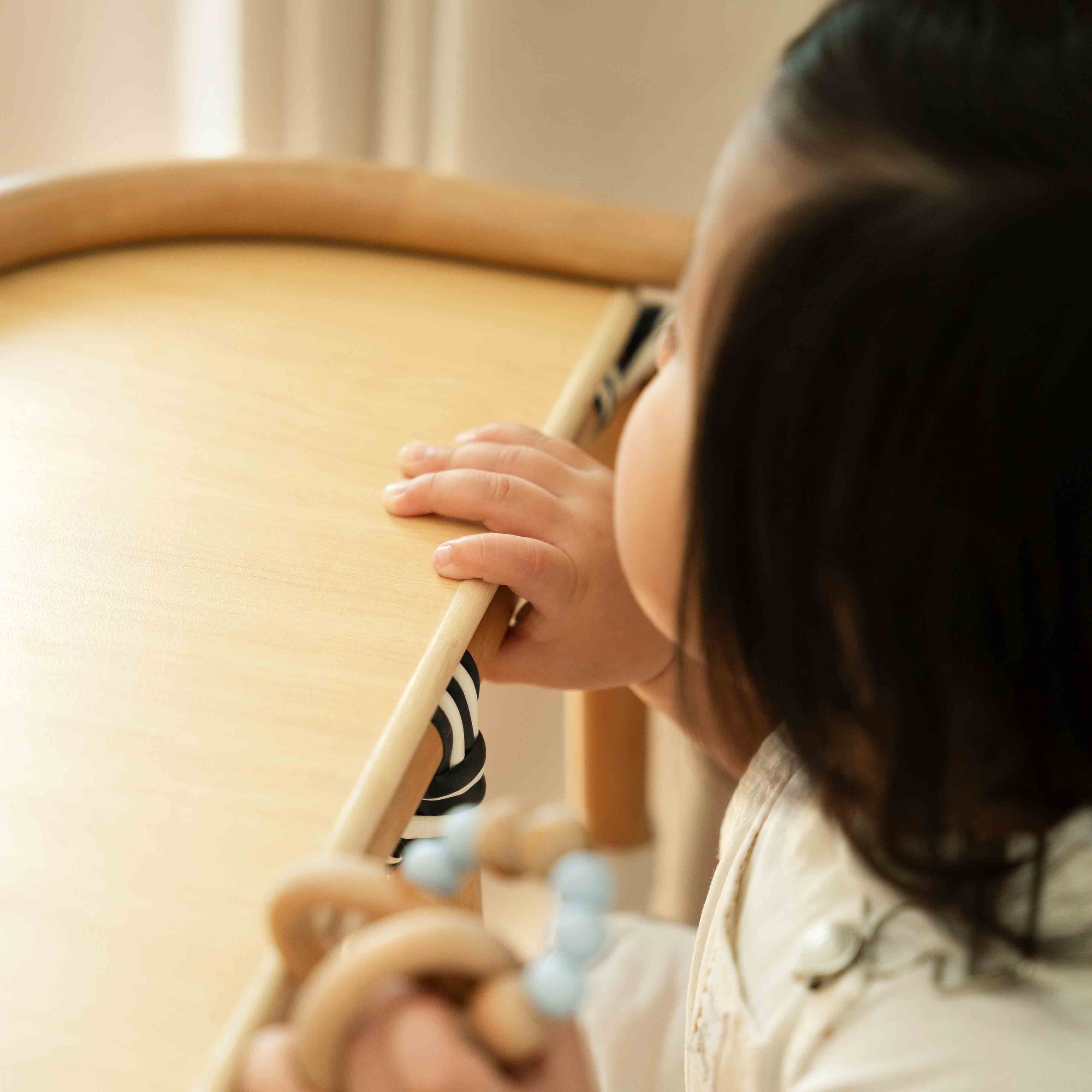 Close-up of the side edge of the tray on the Handcrafted rattan wicker Tumbuh Kids High Chair by MOMIJI.
