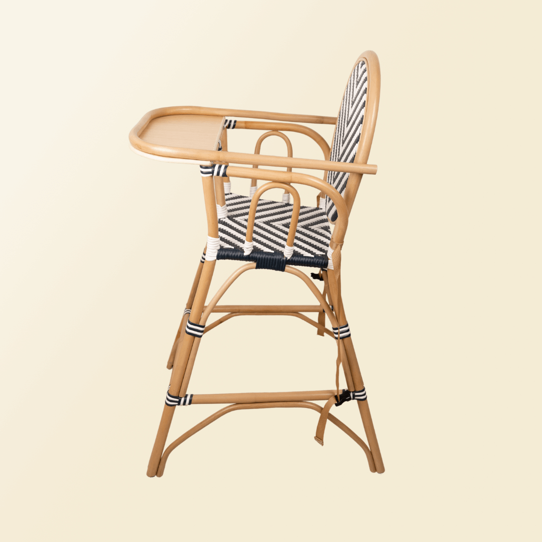 Side view of the handcratfedrattan wicker Tumbuh Kids High Chair by MOMIJI showing a sturdy, child-safe structure with black and white woven details on the backrest, seat, and reinforced wrapped joints.