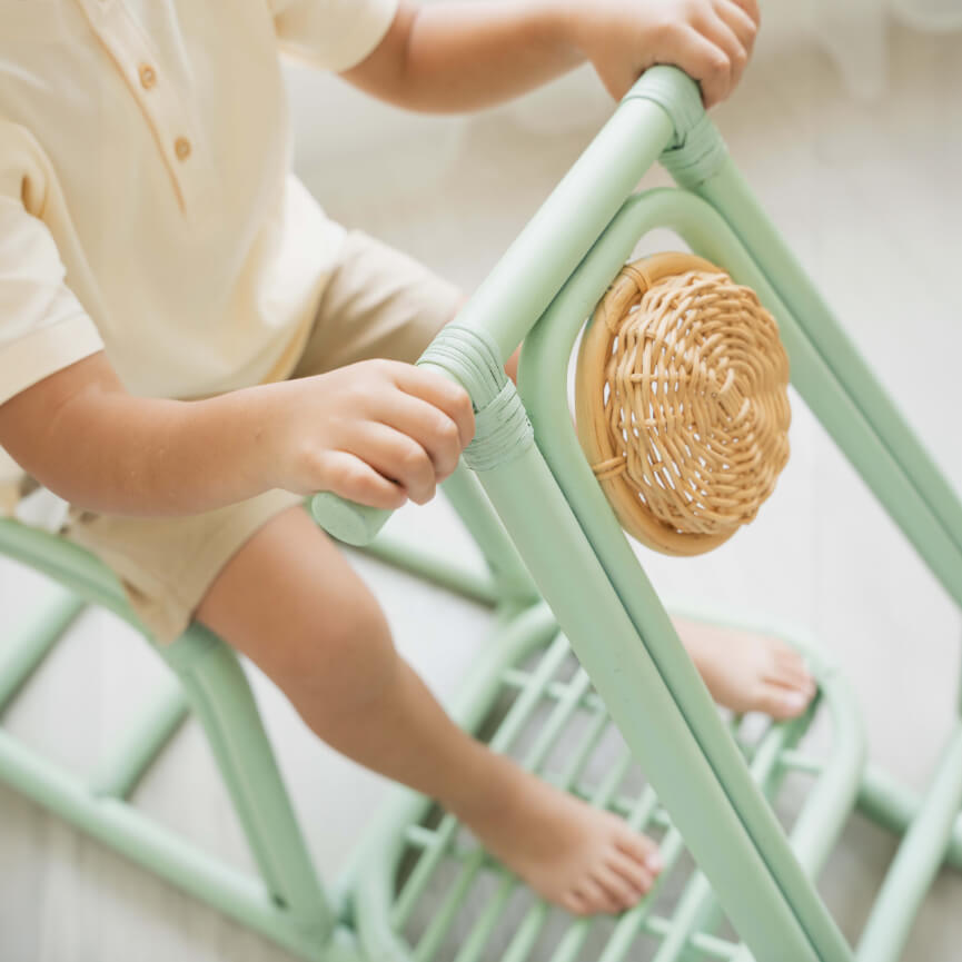 Close-up of a child holding the handle of the Vespa Rocker – Mint by MOMIJI, showing the front design.
