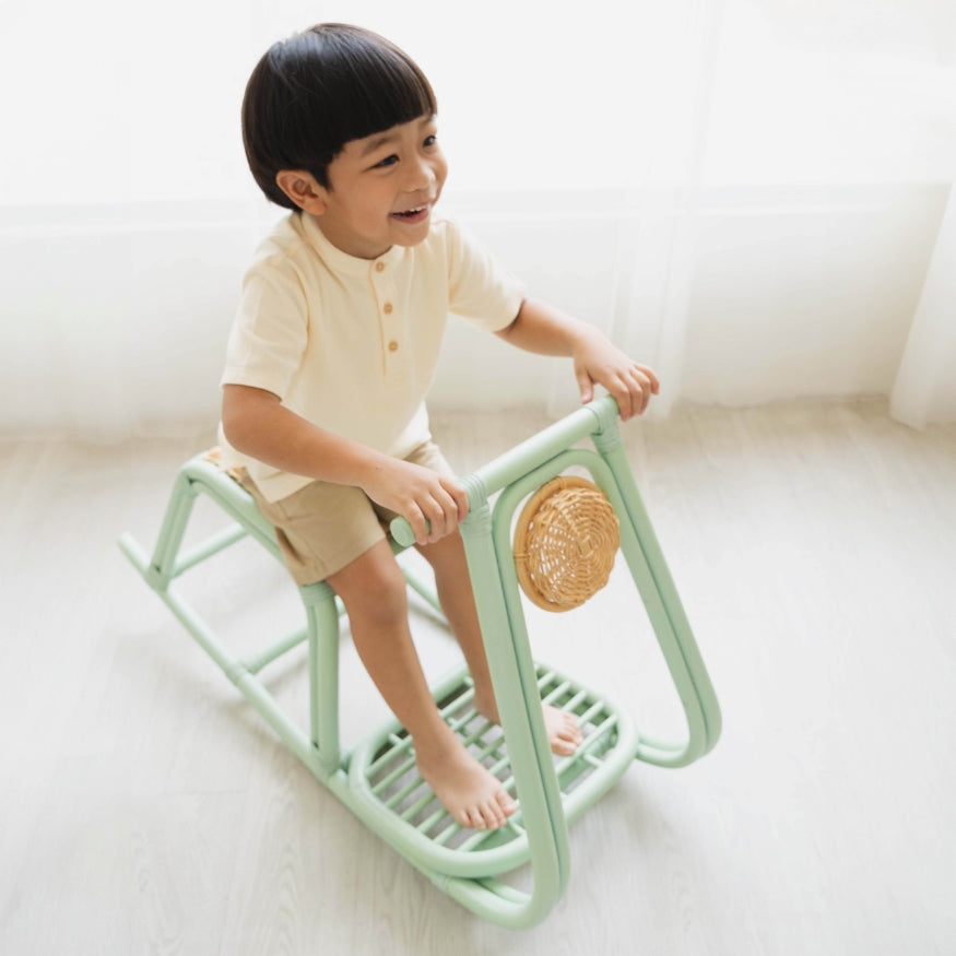 Top view of a child riding the Vespa Rocker – Mint by MOMIJI in play room.