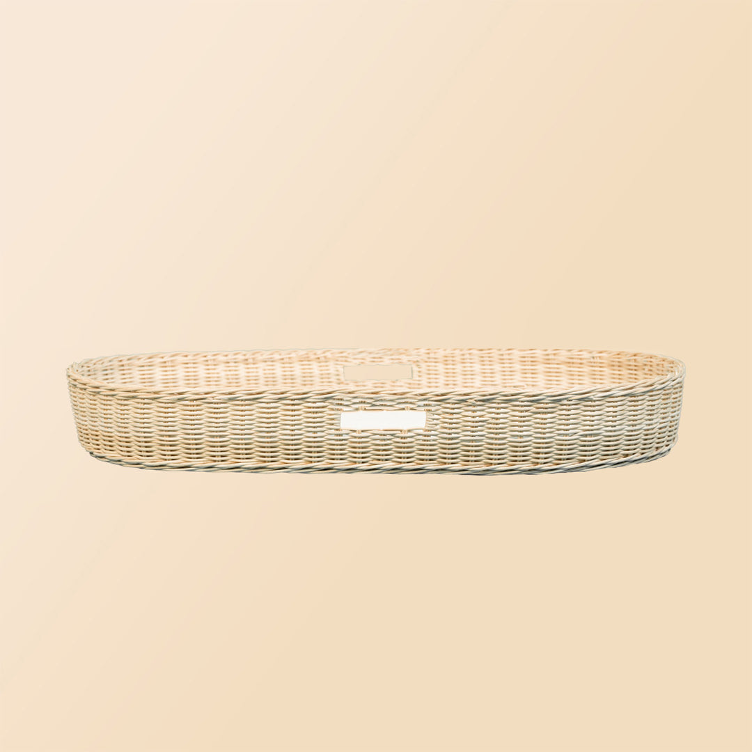 Side view of the Xander Changing Basket by MOMIJI, showing its curved woven shape.