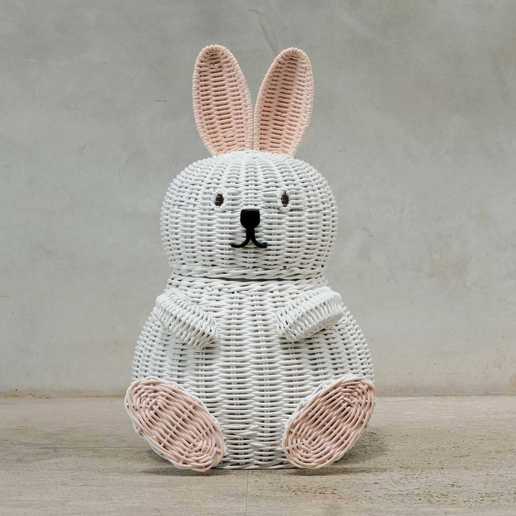 Front view of a handcrafted white rattan wicker bunny basket by MOMIJIwith soft pink ears and feet, featuring rounded eyes, wicker hands, and black nose detail.