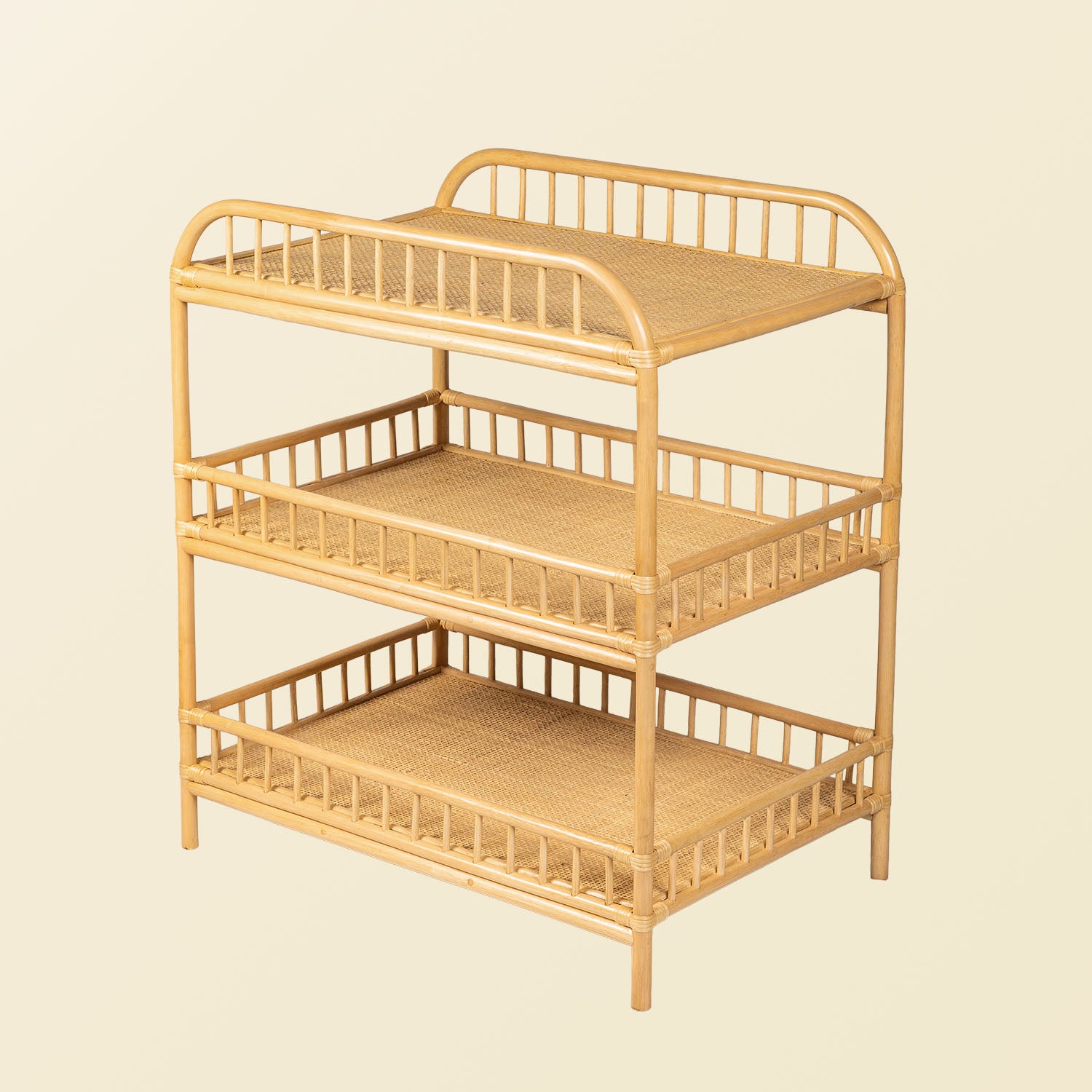 Angled view of the handcrafted Lestari changing table and shelves by MOMIJI in beige natural rattan, highlighting the wrapped rattan joints and sturdy frame construction.