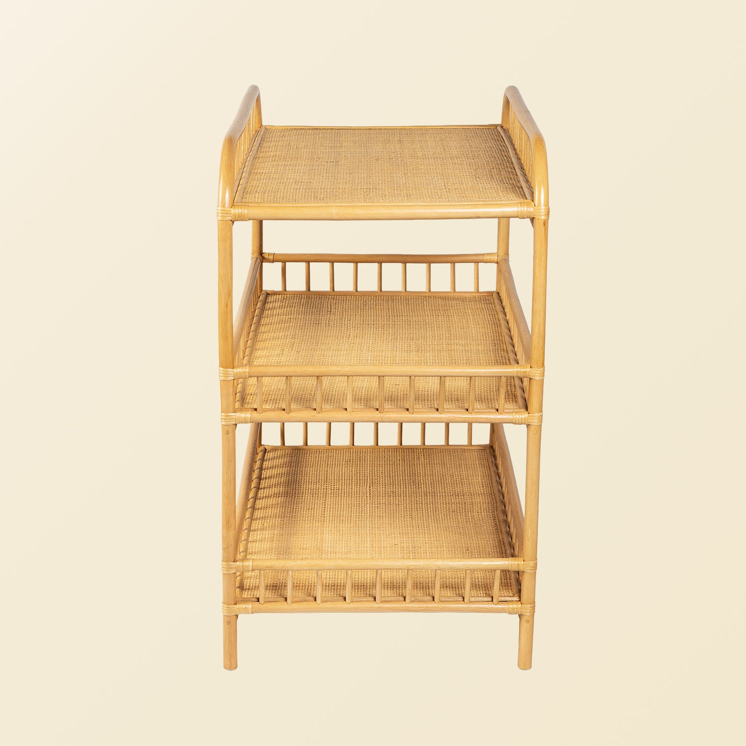 Front view of the handcrafted Lestari changing table and shelves by MOMIJI in beige natural rattan, showing the rattan wicker bases on each shelf.