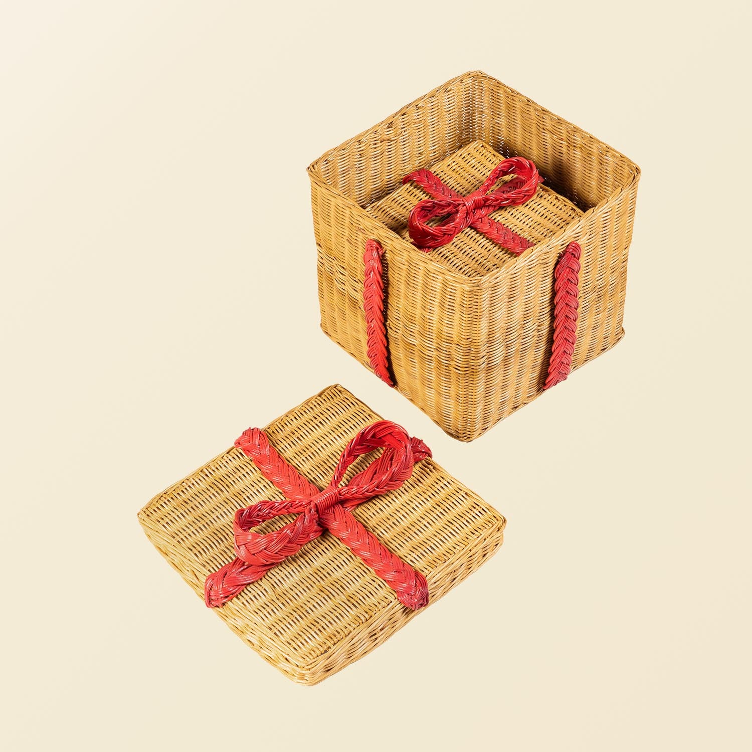 Two handcrafted rattan wicker storage gift boxes by MOMIJI with red ribbon of rattan wicker on a beige background, showing the large box open with the smaller box stored inside.