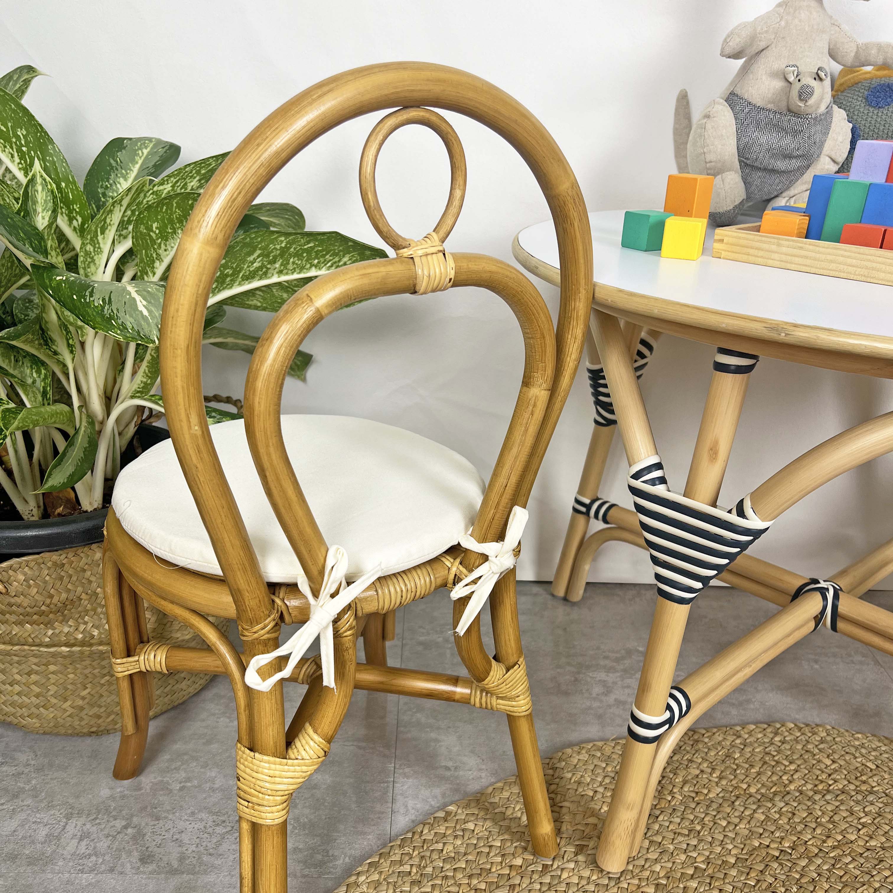 Back view of the handcrafted rattan wicker Amélie Kids Chair by MOMIJI, highlighting the beautifully woven binding details and child-safe backrest design, showcasing natural rattan craftsmanship and sturdy construction in a bright indoor setting.