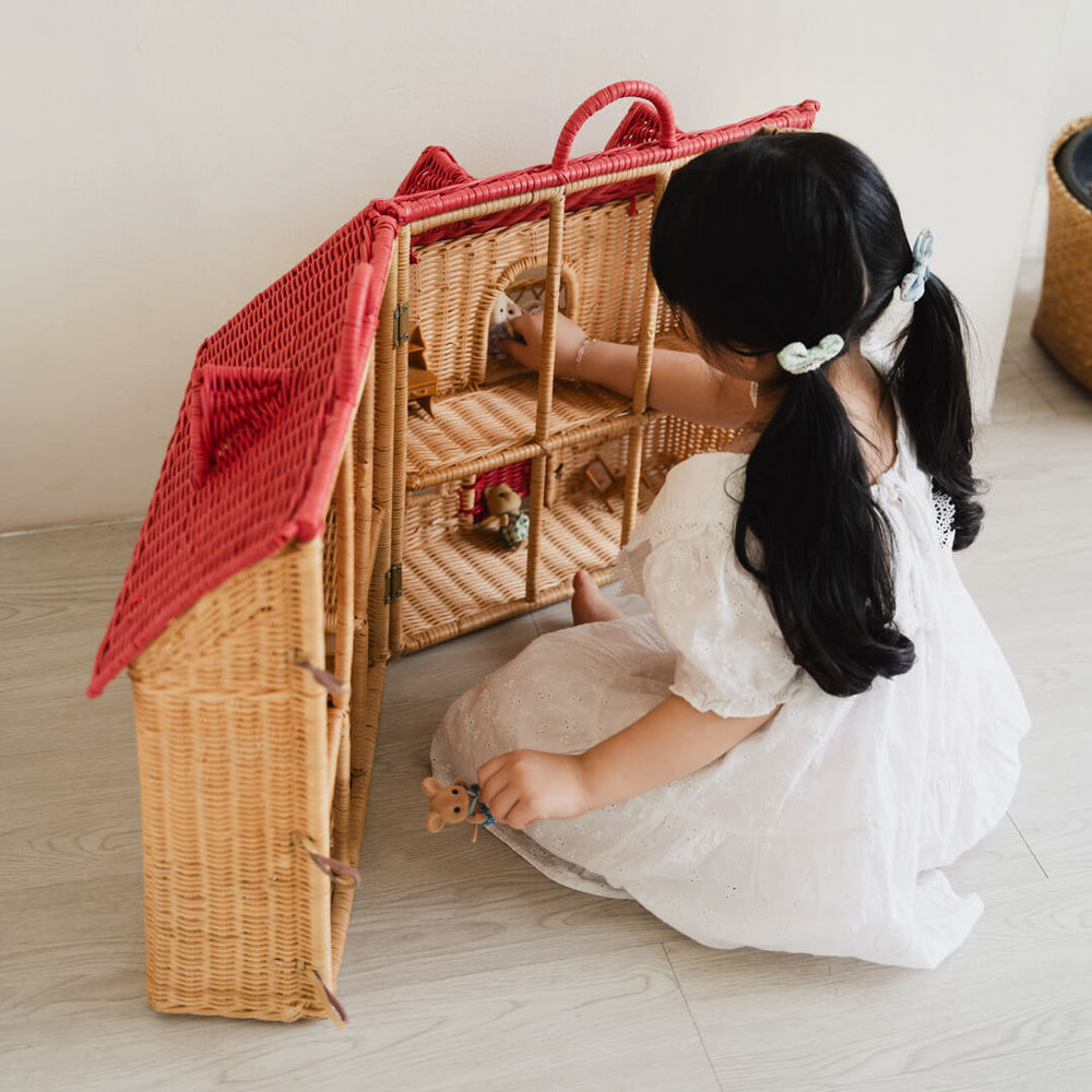 Child playing and placing figurines inside the Amy Dollhouse Tote by MOMIJI.