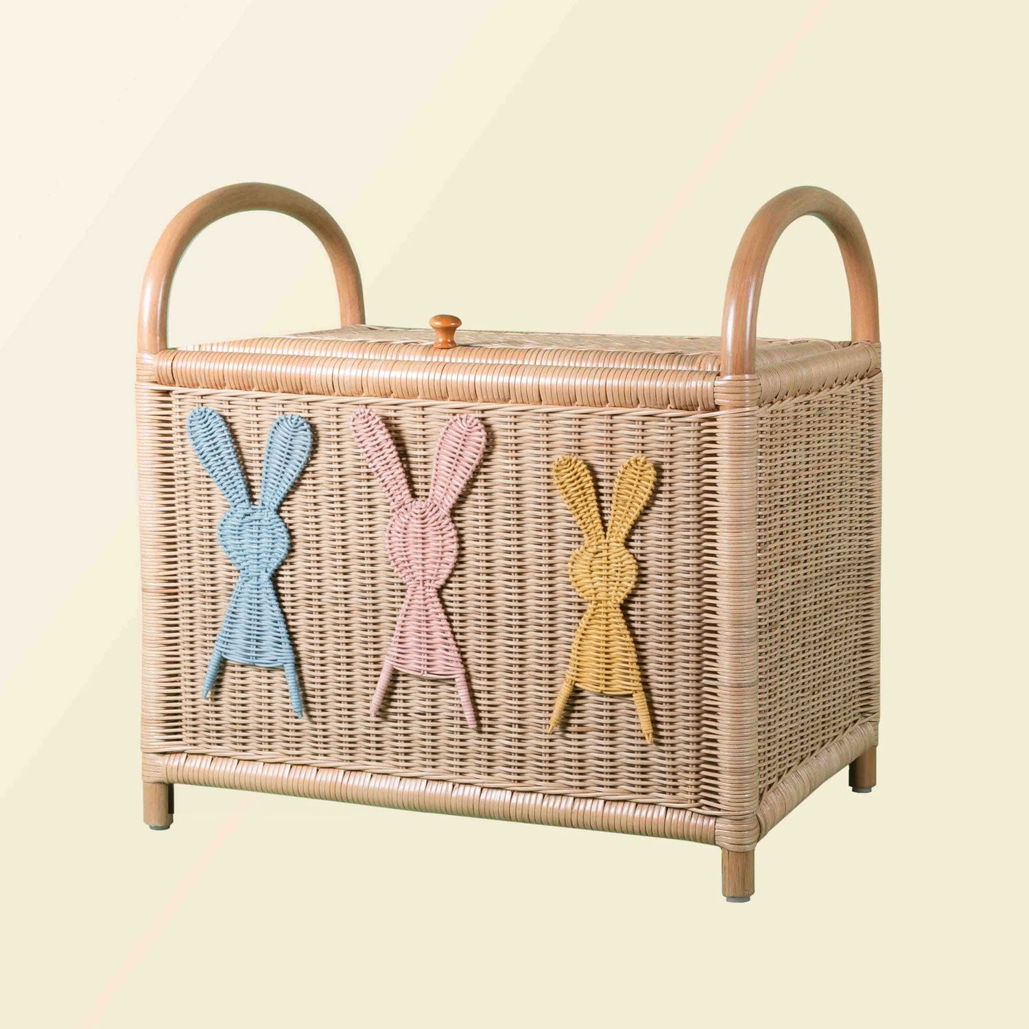 Wicker rattan toy chest with colorful rabbit designs on a light background