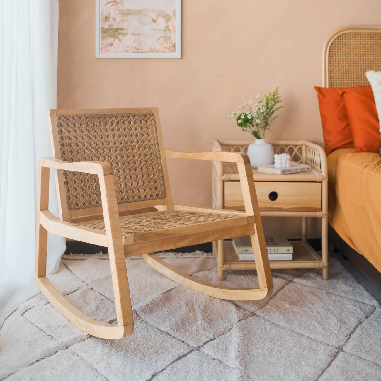 Angled view of the Anya Rocking Chair by MOMIJI styled in a bedroom with a bedside table and bed.