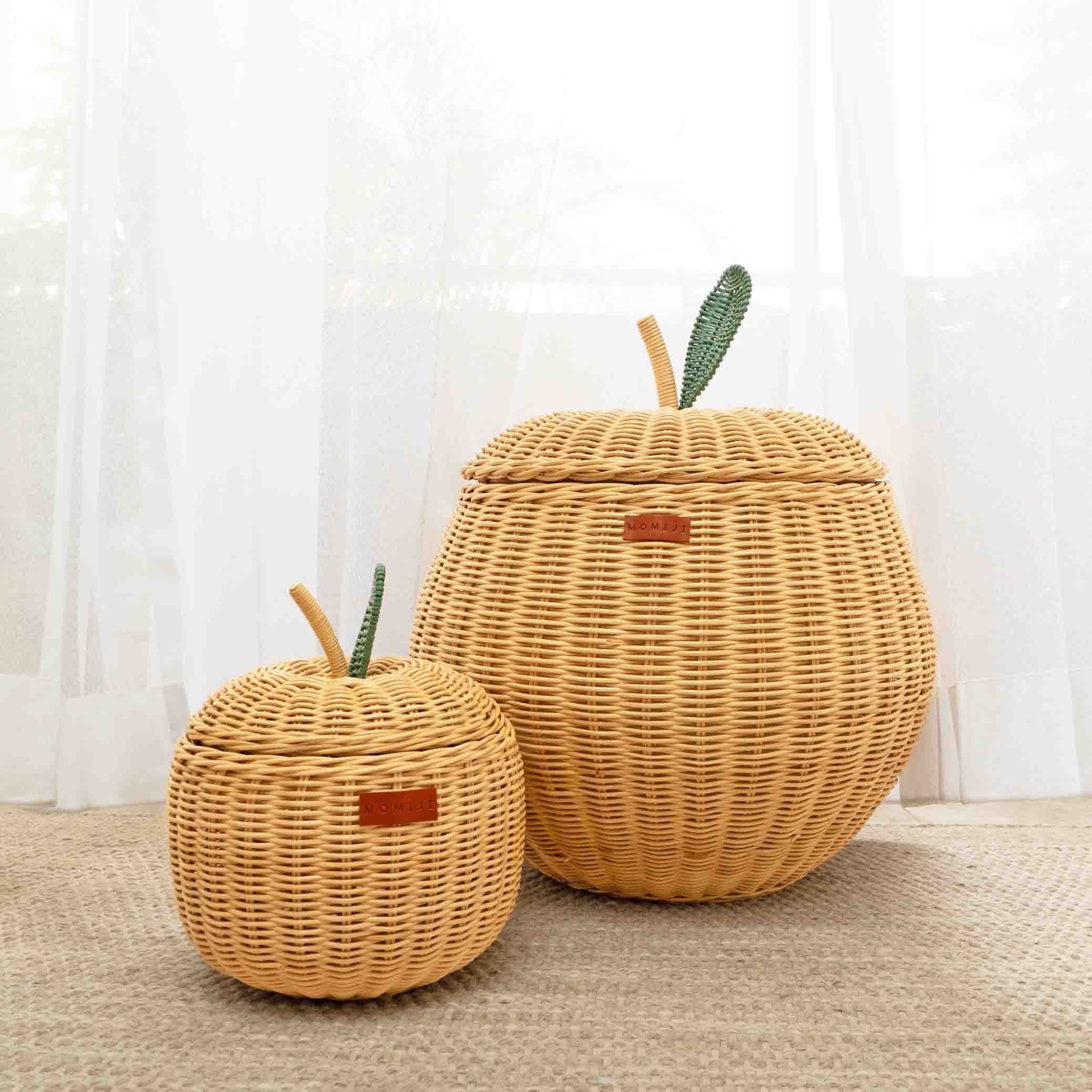 A front view of a small sized natural apple rattan storage basket next to a medium sized natural apple rattan storage basket by MOMIJI.