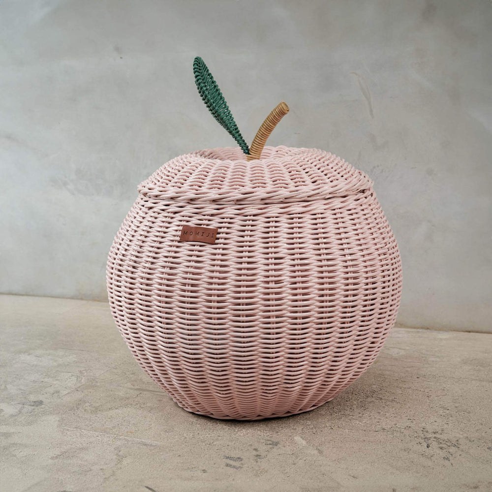 Side view of a pink apple rattan storage basket by MOMIJI in medium size.