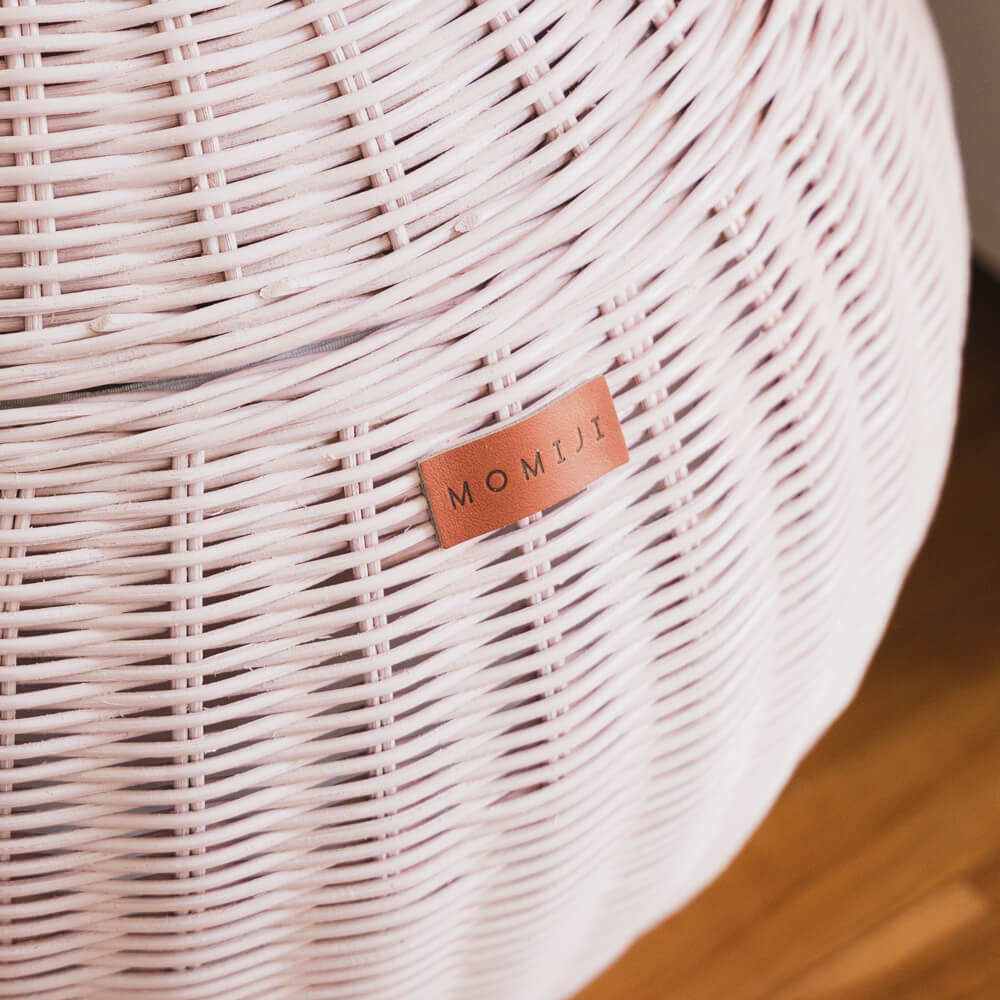 Close up view of the logo of pink apple rattan storage basket by MOMIJI.