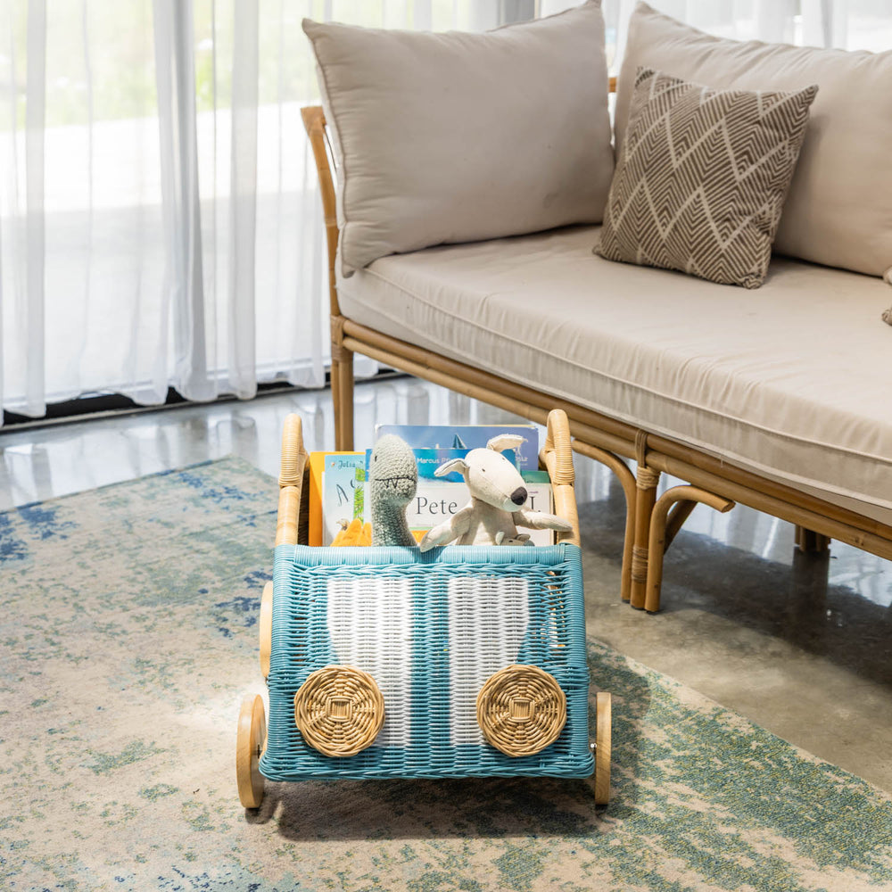 Archie Storage Wagon by MOMIJI filled with children’s toys on a rug indoors.