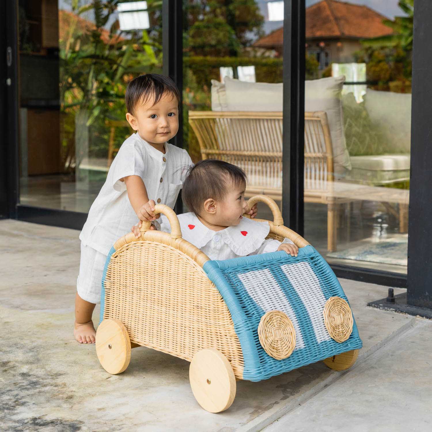 Two children playing with the Archie Storage Wagon by MOMIJI outdoors.