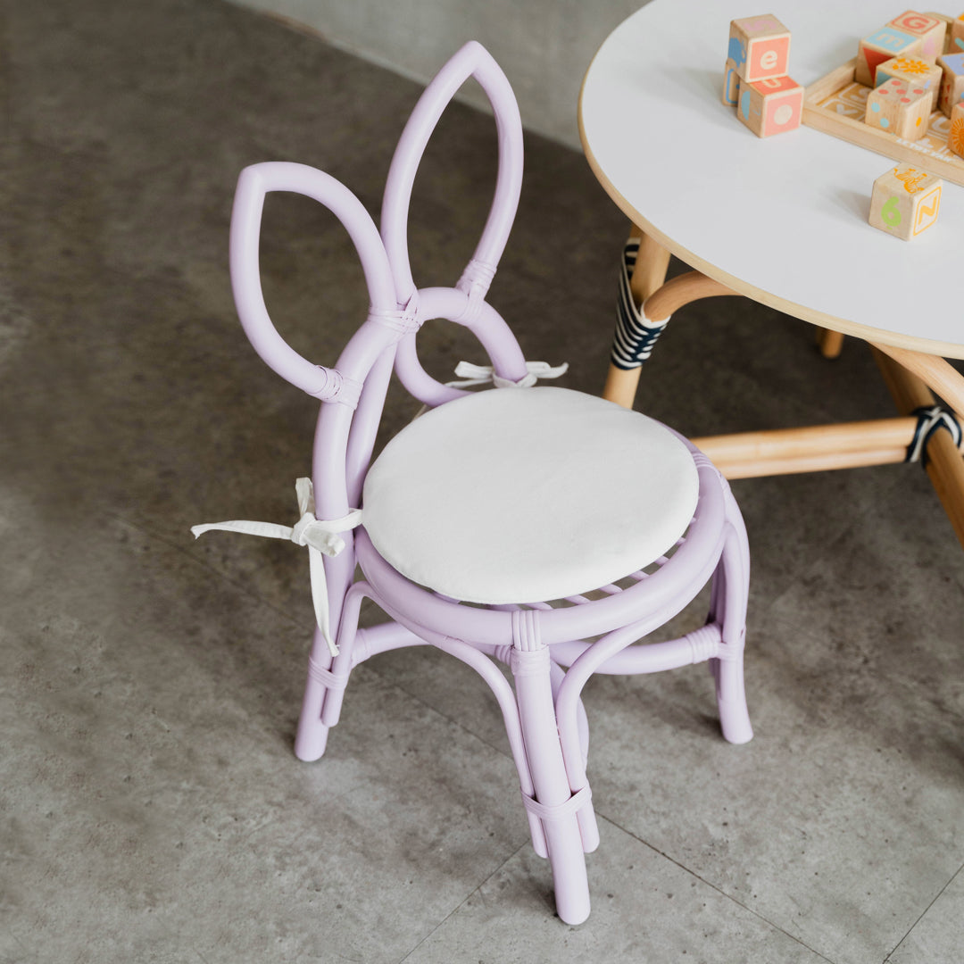 Handcrafted purple rattan wicker Butterfly Kids Chair by MOMIJI styled with an Aulia Kids Table in a playful children's room.