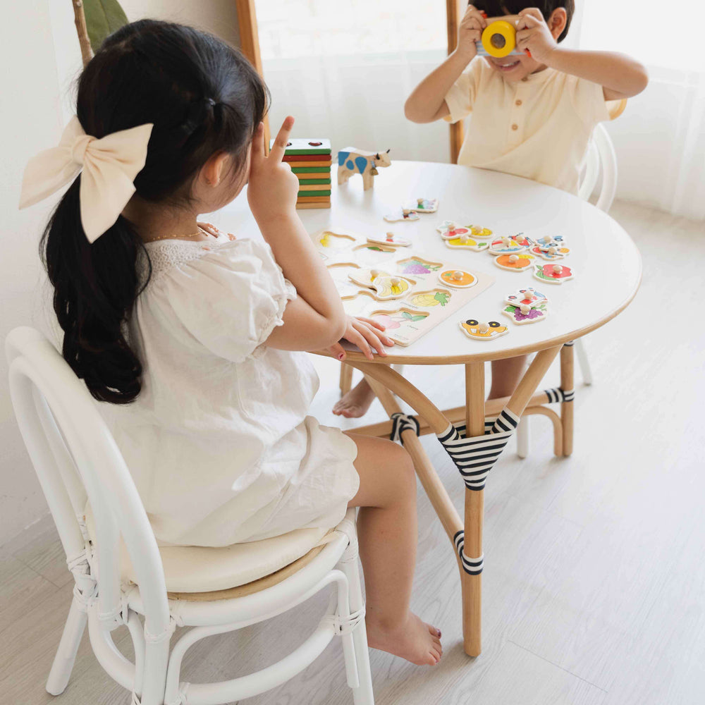 Two children playing with a toy camera at the Aulia Kids Table – Medium by MOMIJI.