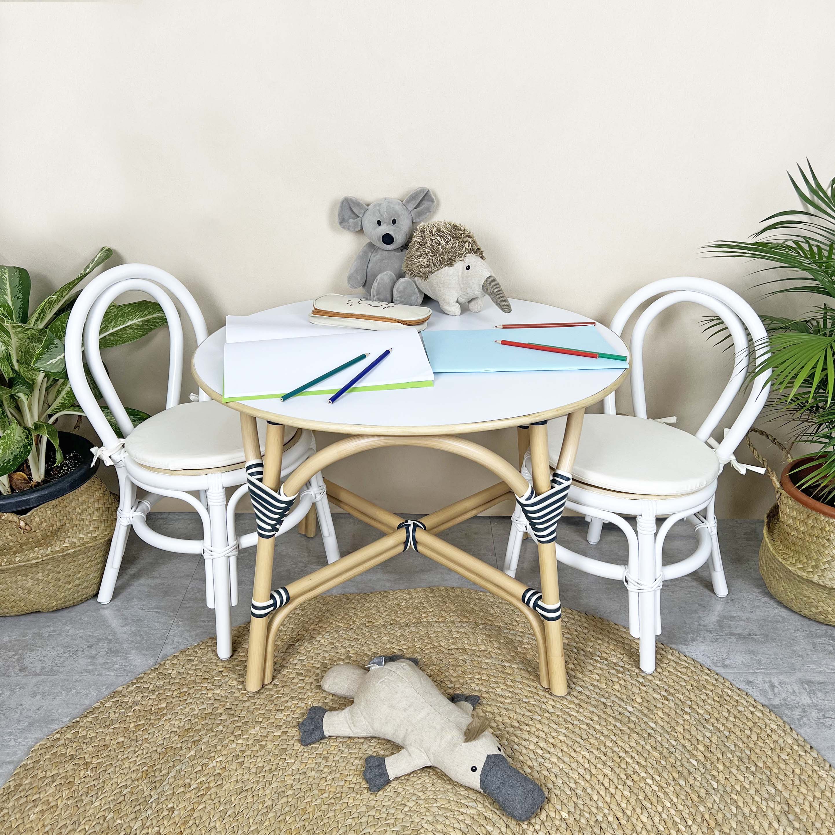 Aulia Kids Chairs by MOMIJI placed beside an Aulia Kids Table with stationery and toys in a room with plants.
