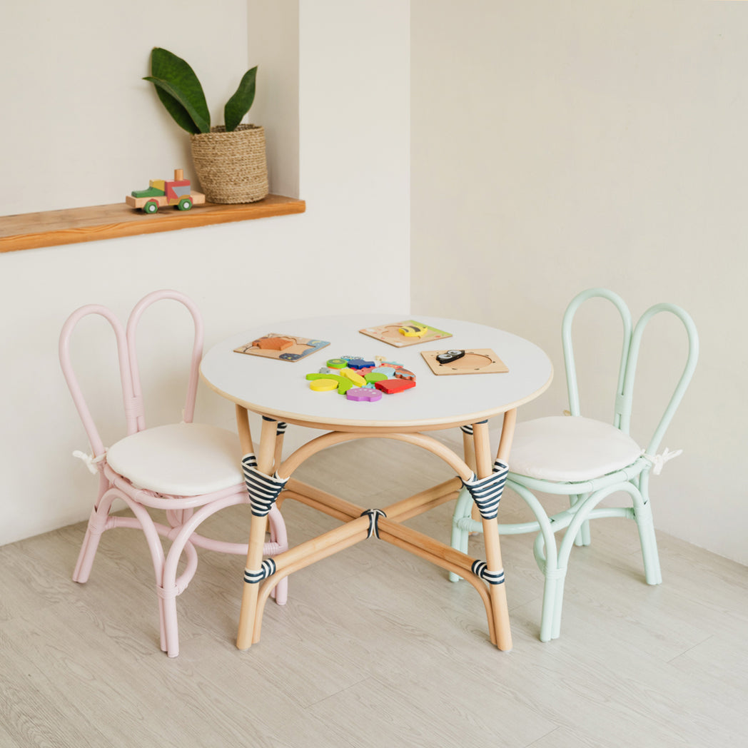 Pink and Mint Green handcrafted rattan wicker Kids Bunny Chairs by MOMIJI paired with an Aulia Kids Table, styled with toys in a playful children's room.