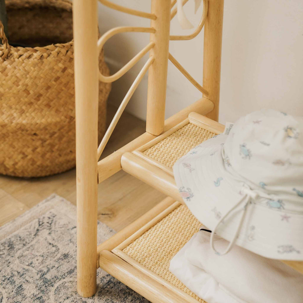 Close-up of the two-tier woven shelves of the handcrafted natural rattan Belle Kids Montessori Clothing Rack by MOMIJI, showcasing practical storage space for children's accessories and everyday essentials.