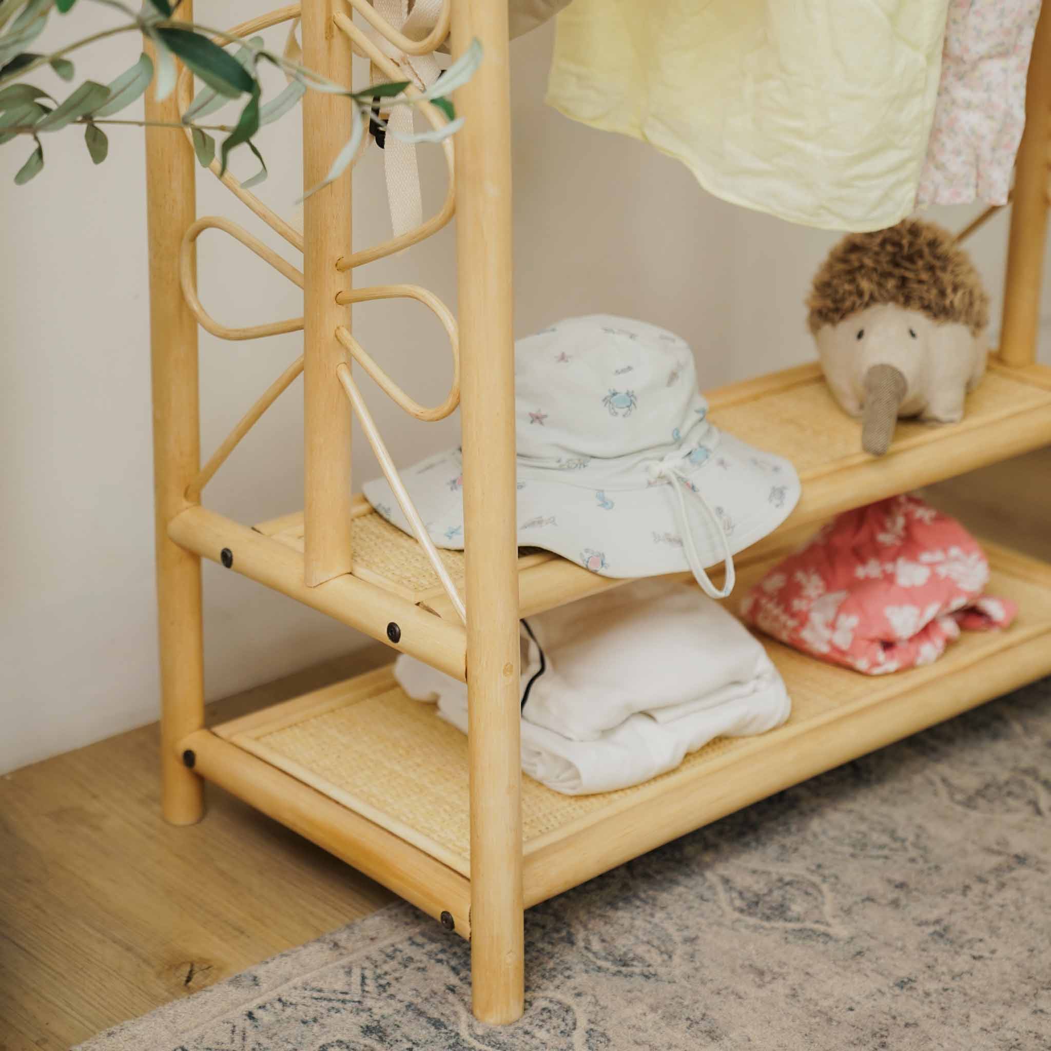 Close-up of the handcrafted natural rattan Belle Kids Montessori Clothing Rack by MOMIJI, highlighting the woven shelf detailing, decorative craftsmanship, and easy-to-assemble design.