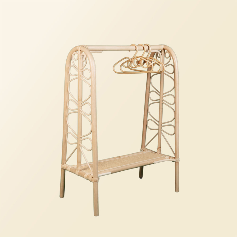 Angled view of the Belle Kids Montessori Clothing Rack by MOMIJI with hangers attached.