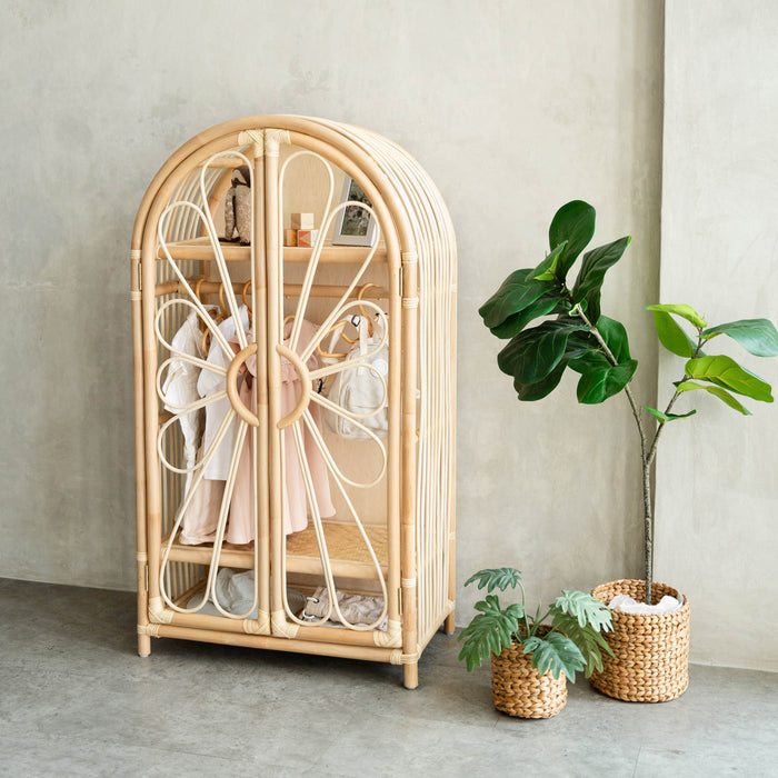 Handcrafted rattan wicker Blossom Kids Wardrobe by MOMIJI styled with children’s clothes and plants, offering sustainable and Montessori-inspired wardrobe storage for kids.