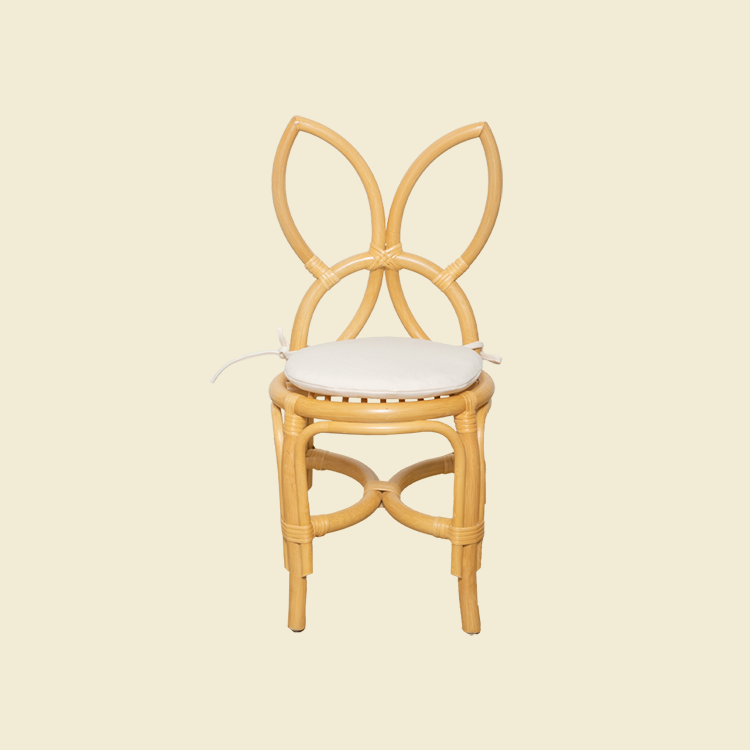 Front view of handcrafted rattan wicker Butterfly Kids Chair by MOMIJI innatural with white cushion, featuring a butterfly wing-shaped backrest.