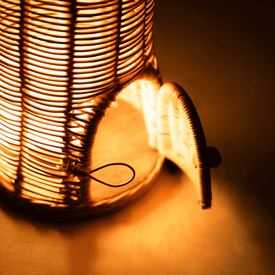 Close-up of the open light compartment of the Cactus Kids Coat Light Stand by MOMIJI, showing the warm glow from inside the rattan structure.