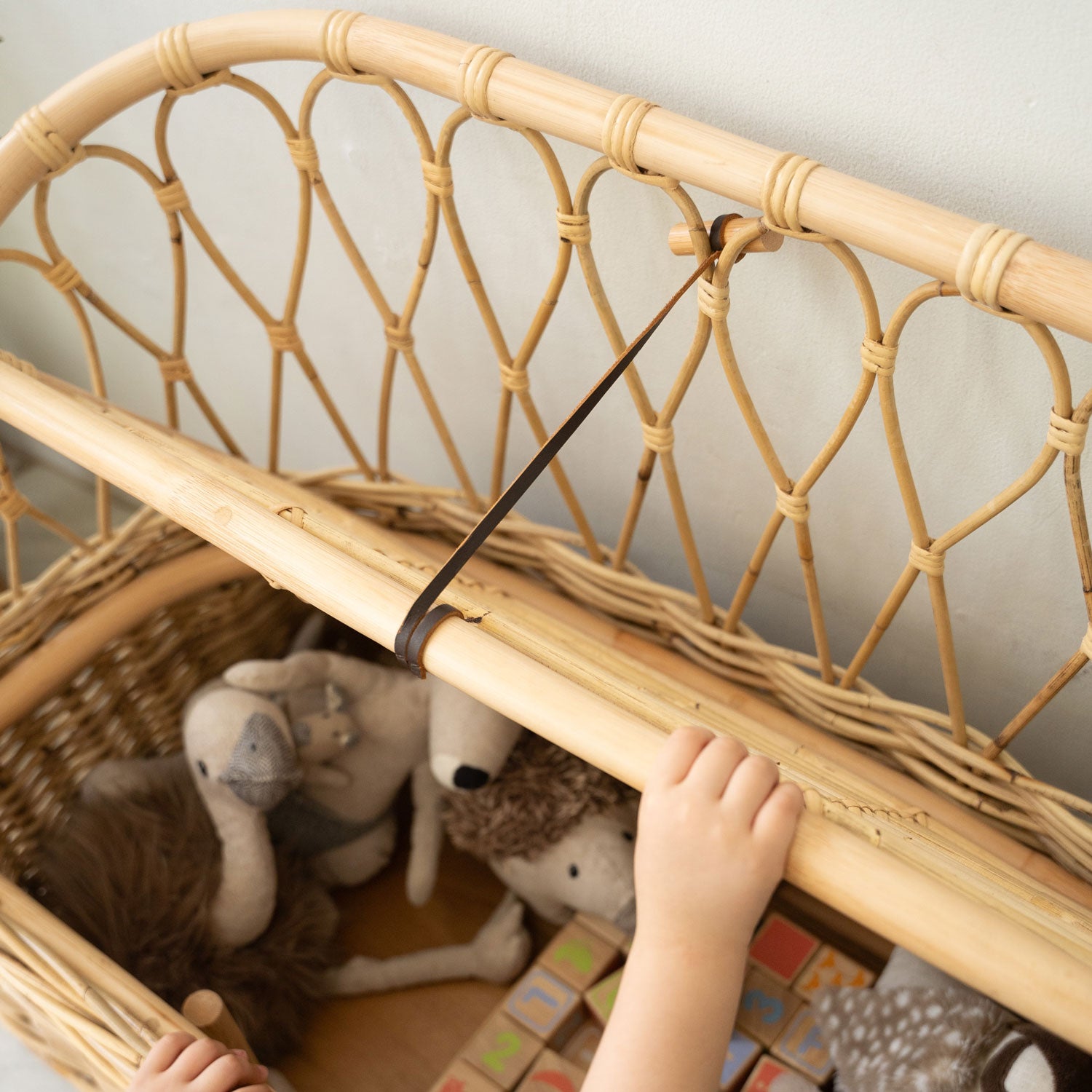 Close-up of the vegan leather lid closerdetail on the Handcrafted rattan wicker Callie Kids’ Storage Couch by MOMIJI.