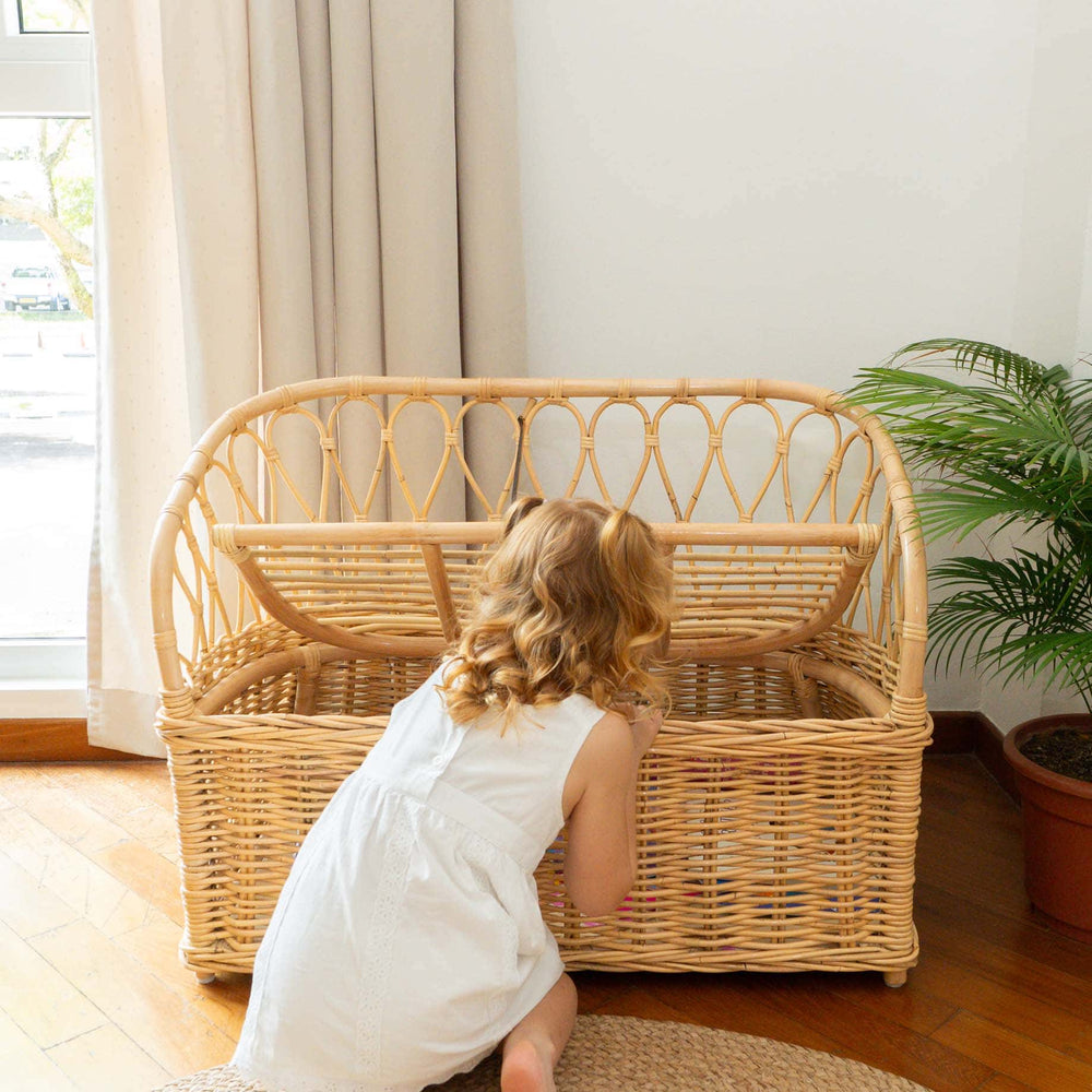 Child playing near the Callie Kids’ Storage Couch by MOMIJI in a room with curtains and plants.