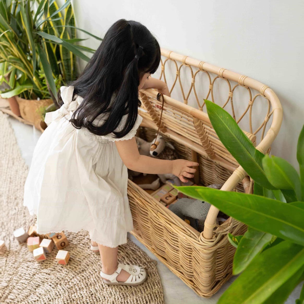 Child playing with toys stored inside the Callie Kids’ Storage Couch by MOMIJI.