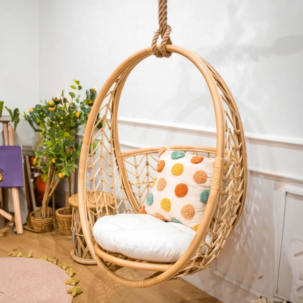 Angled view of the Cross Hatch Hanging Chair by MOMIJI in a room with indoor plants.