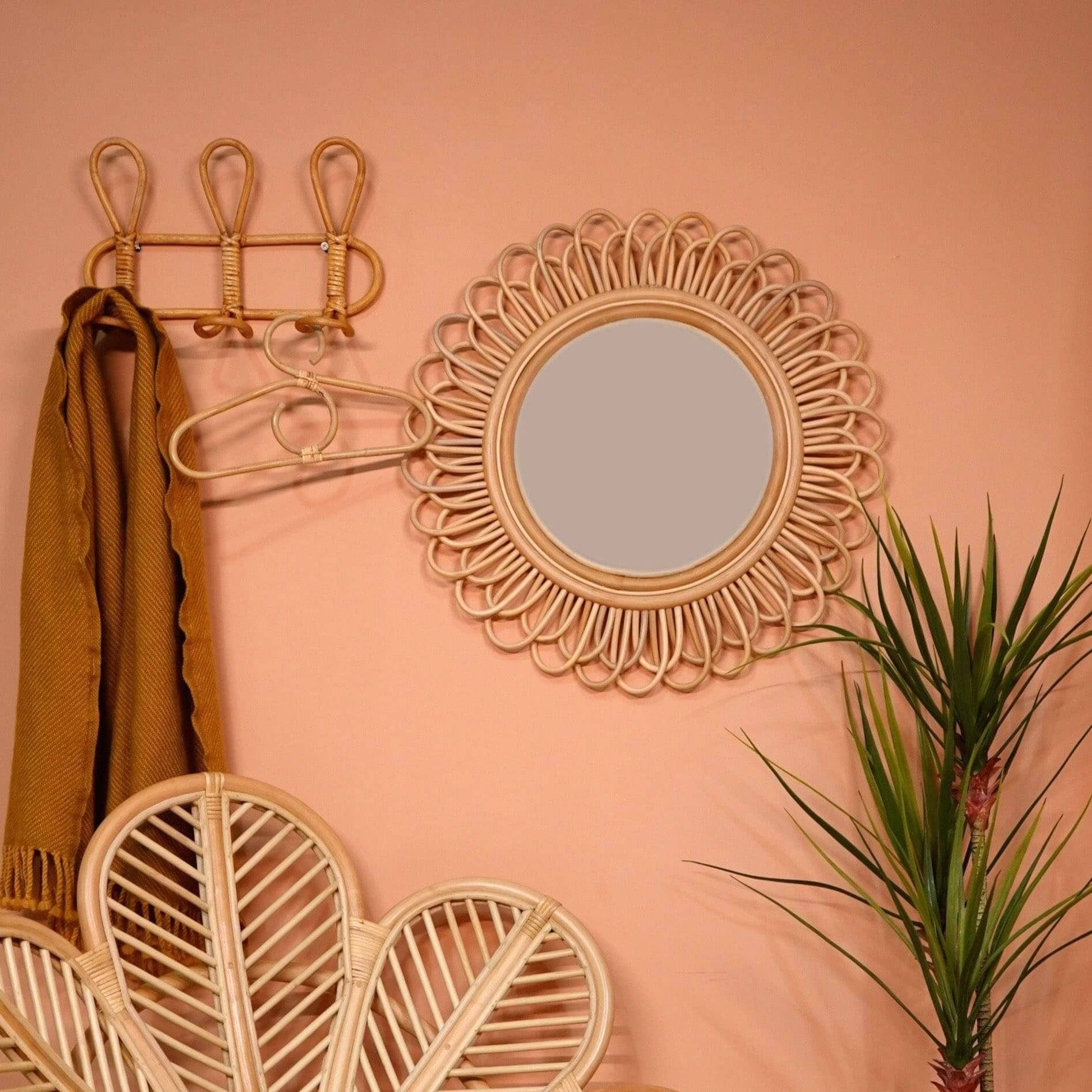 Dahlia Round Mirror by MOMIJI styled on a wall with rattan hooks and plants in a room.